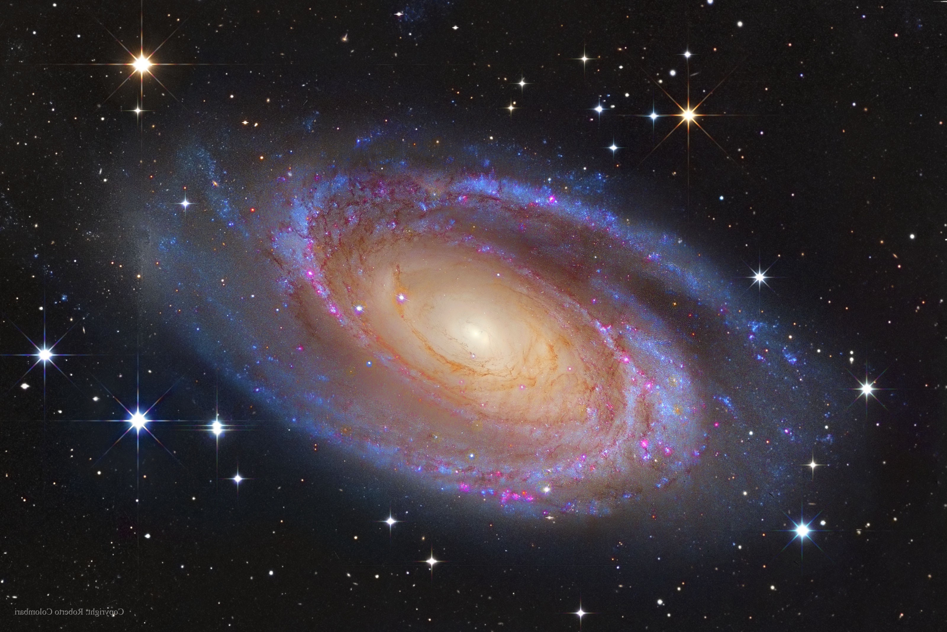 A stunning spiral galaxy with swirling arms of stars, gas, and dust, set against a backdrop of distant stars