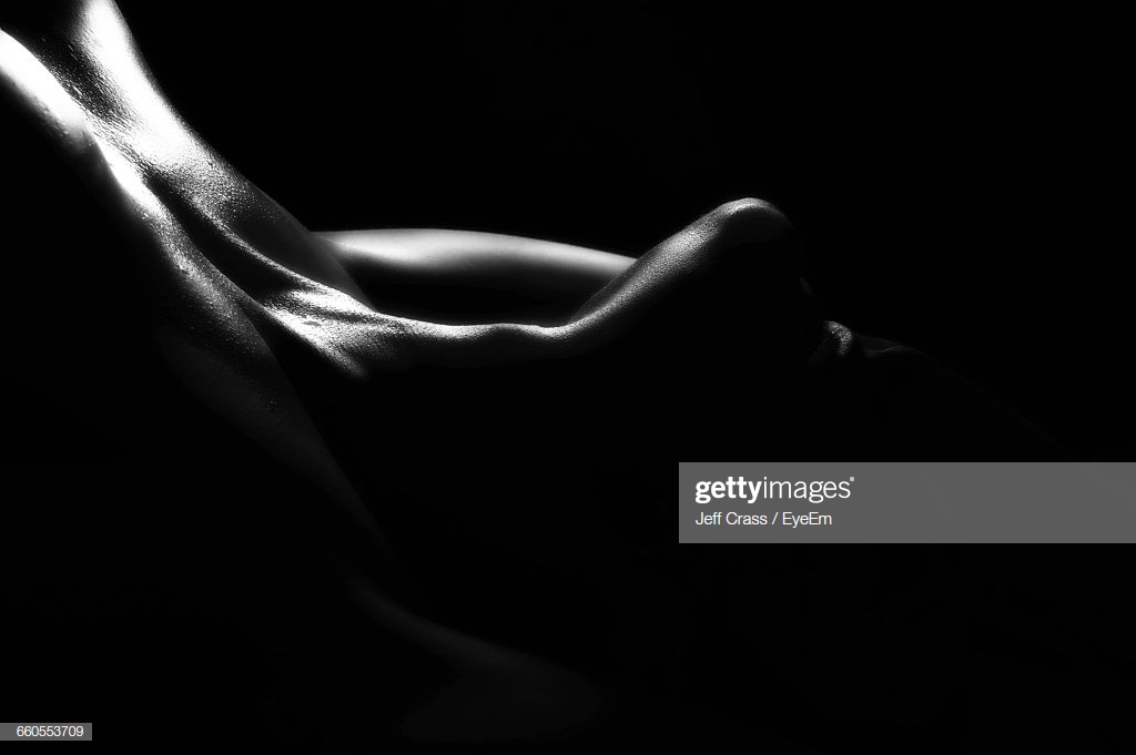 Closeup Of Seductive Woman Against Black Background Stock Photo