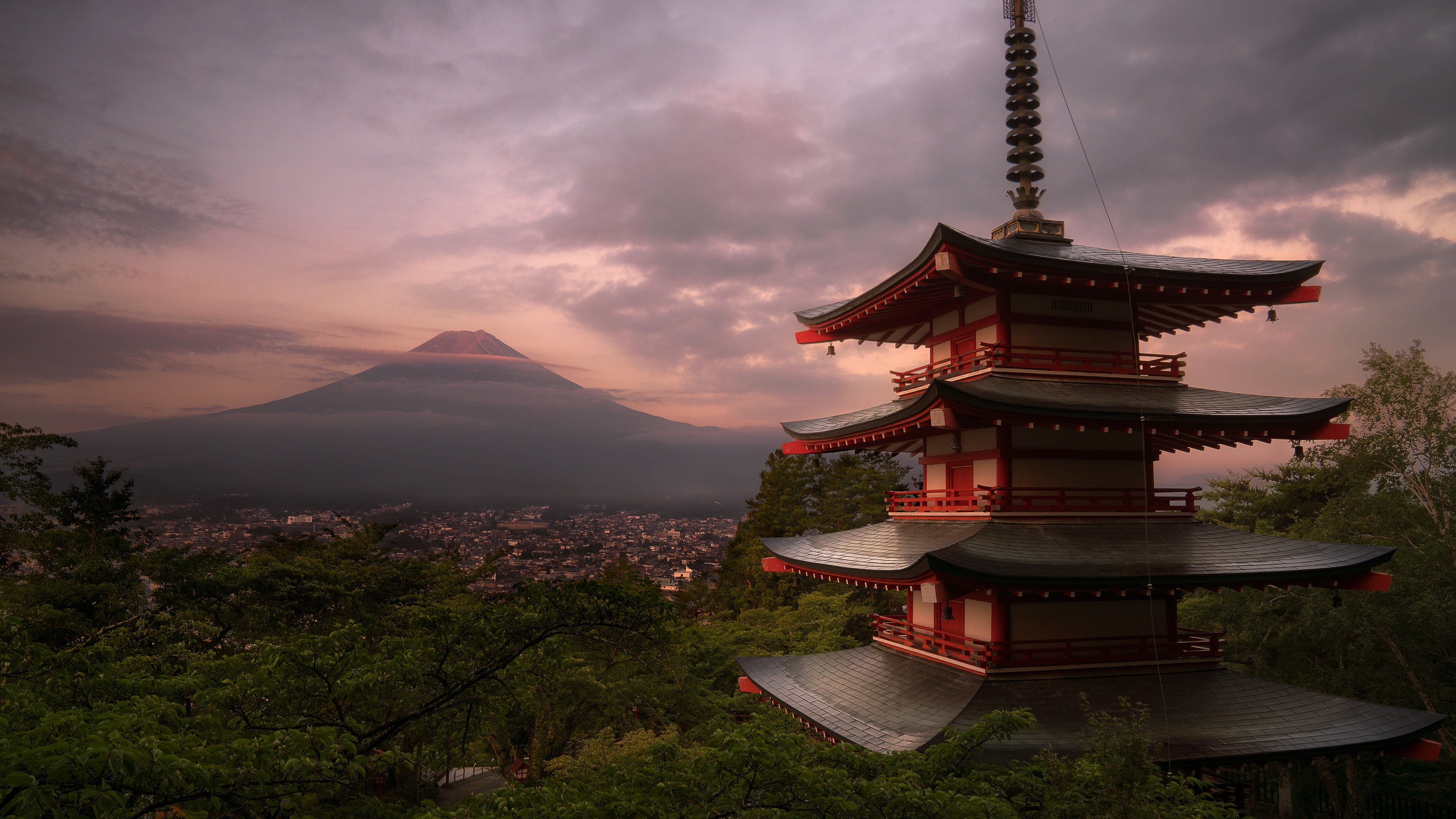 A stunning 4k wallpaper of a traditional Japanese pagoda with Mount Fuji in the background at sunset