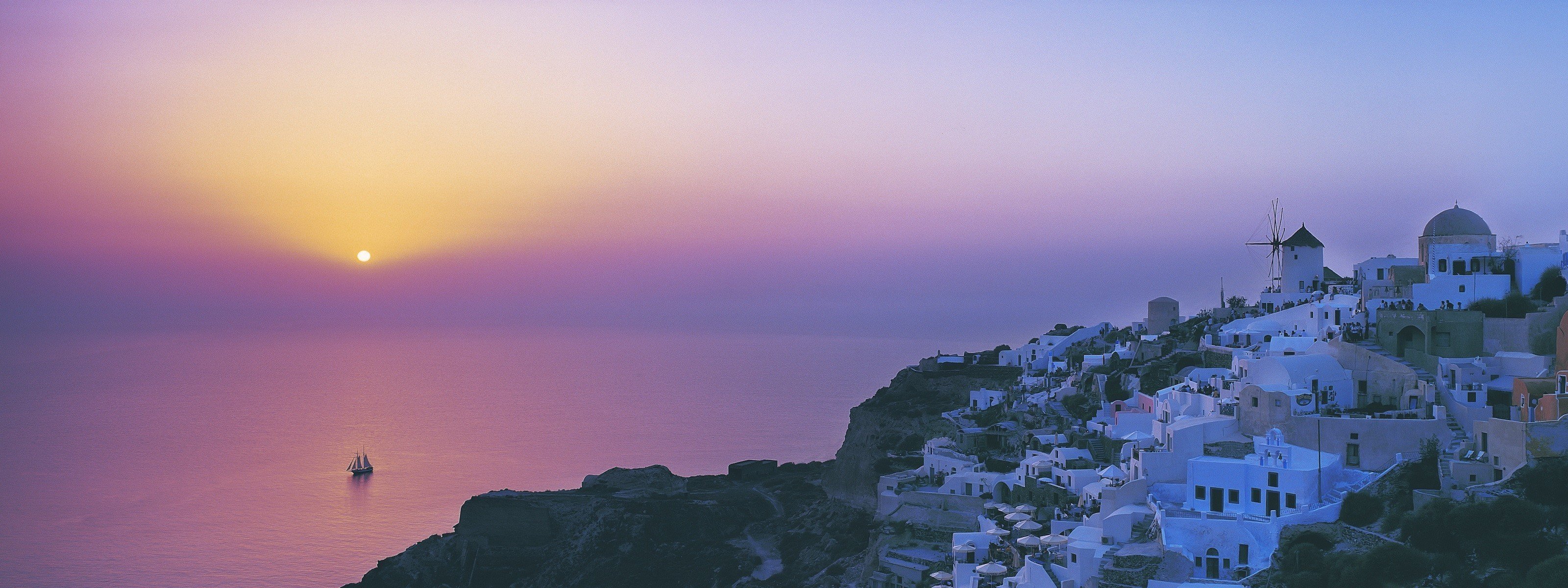 Santorini – hòn đảo thơ mộng nổi tiếng với những ngôi nhà trắng xây dựng trên những con đồi đá vôi. Hình ảnh đưa bạn đến những bãi biển lấp lánh, những cung đường hẹp buốt, và những ngọn đèn pha lê lấp lánh trên bờ biển.