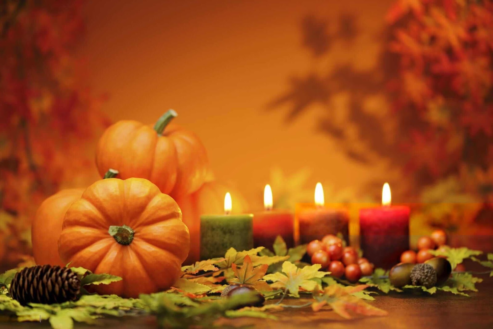 Warm Thanksgiving scene with pumpkins, candles, and autumn leaves