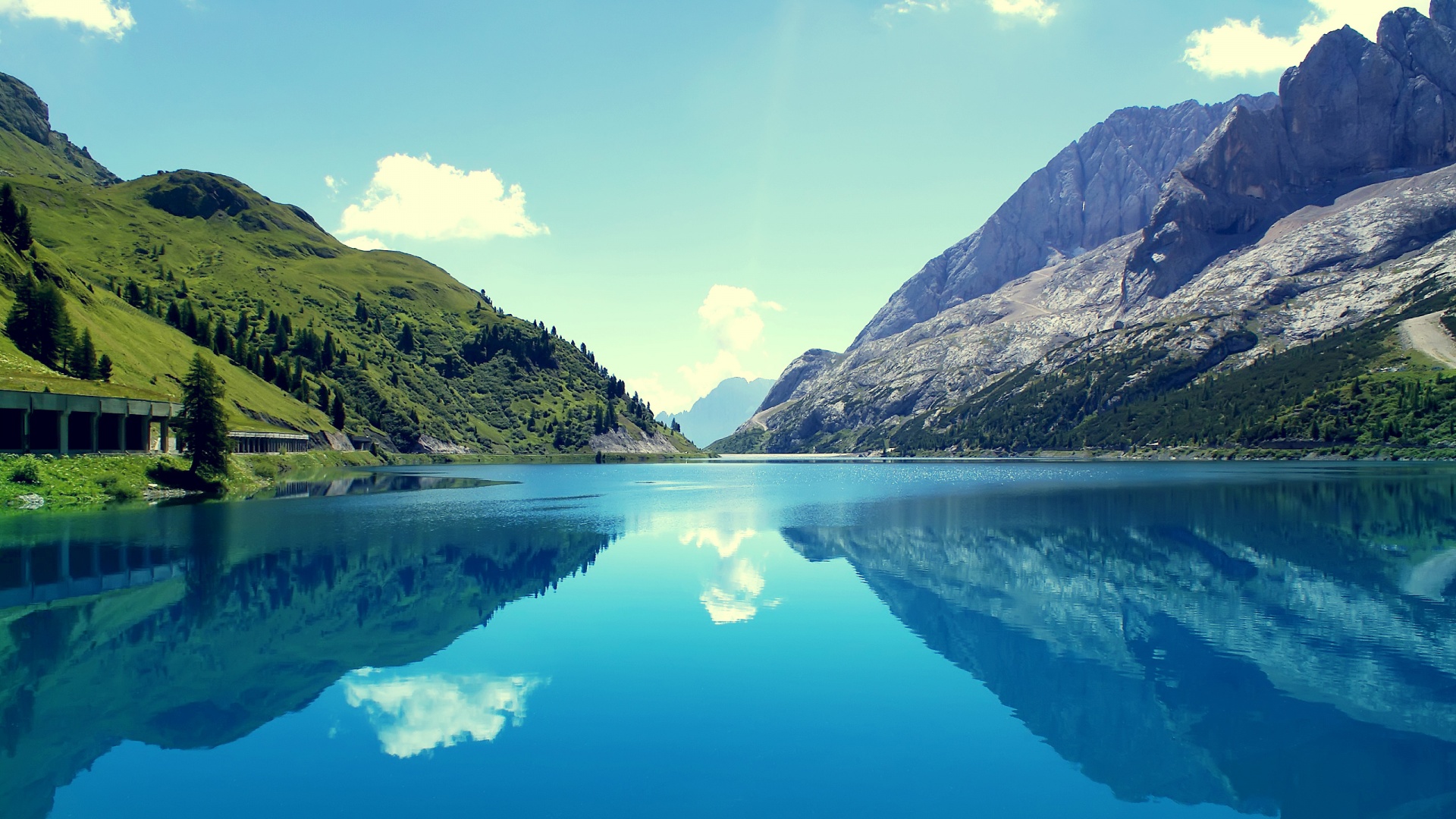 Serene mountain lake reflecting the sky and surrounding peaks