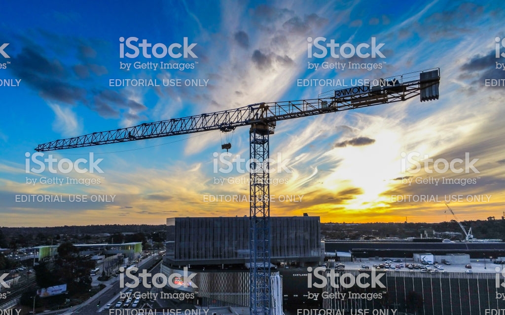 Crane Construction Tower With Sun Setting In The Background Stock