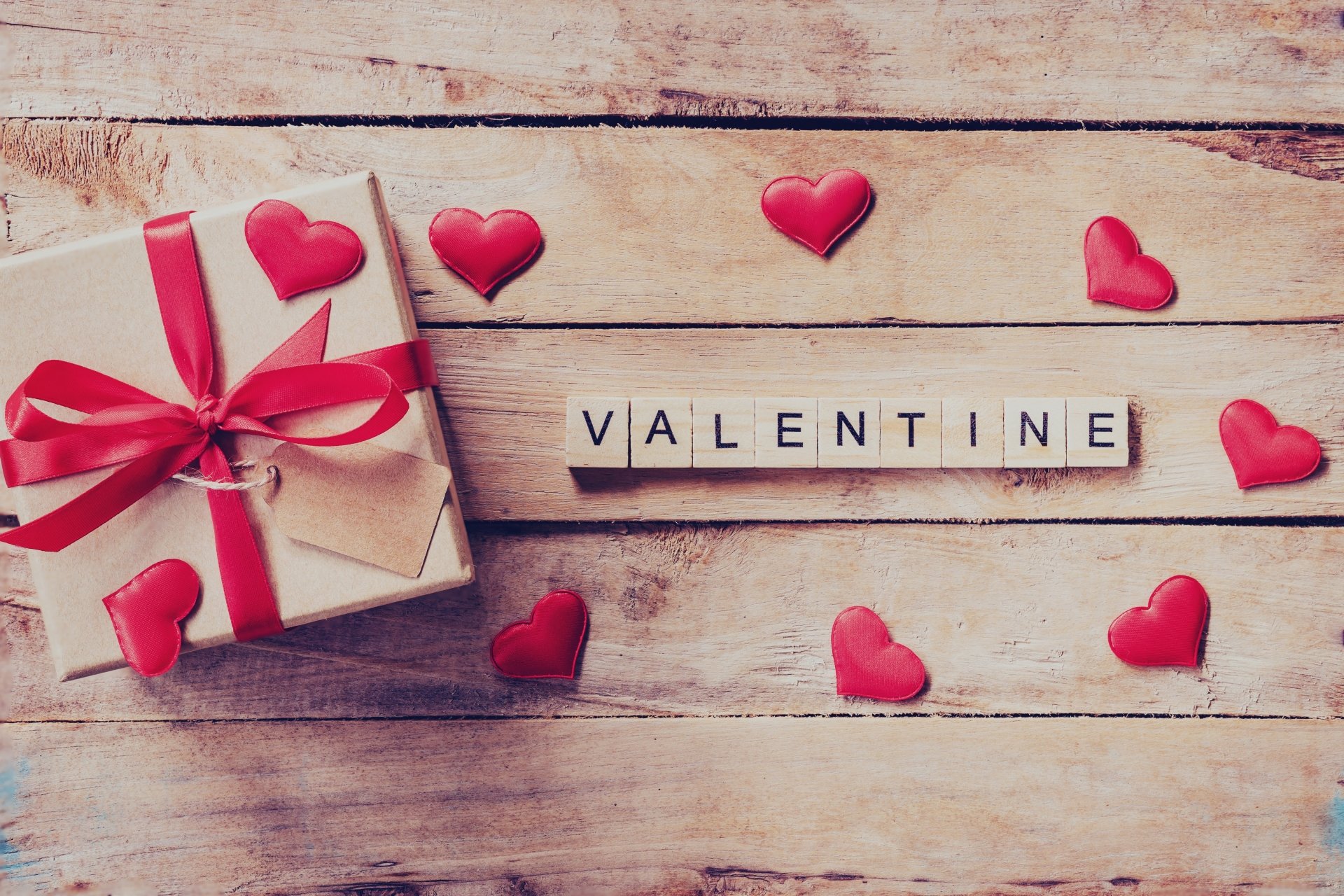 Rustic Valentine's Day scene with gift box, hearts, and wooden letters