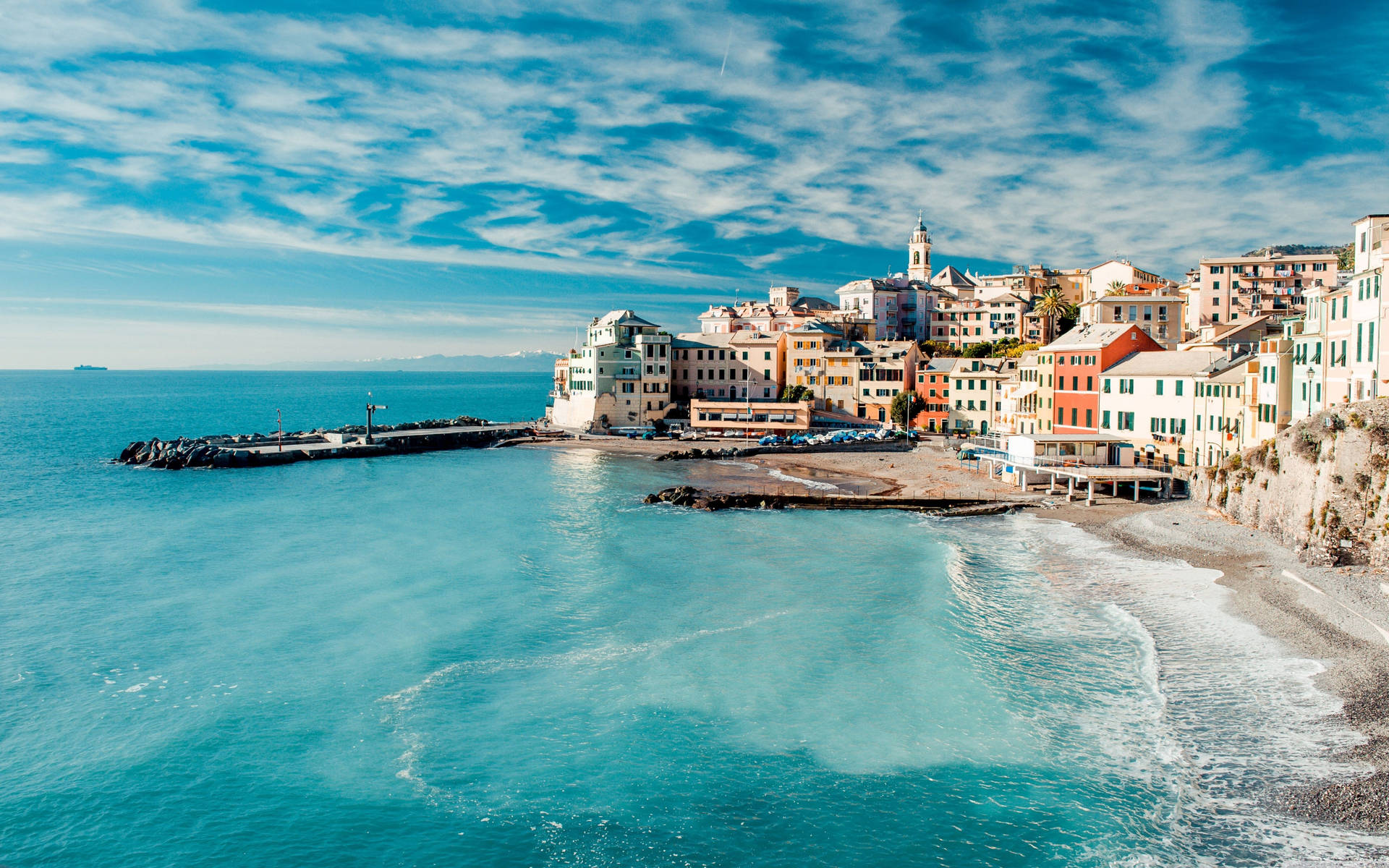 A picturesque coastal town in Italy with colorful buildings nestled along the Ligurian Sea, overlooking a stunning turquoise bay. Perfect for MacBook Pro 4k wallpaper