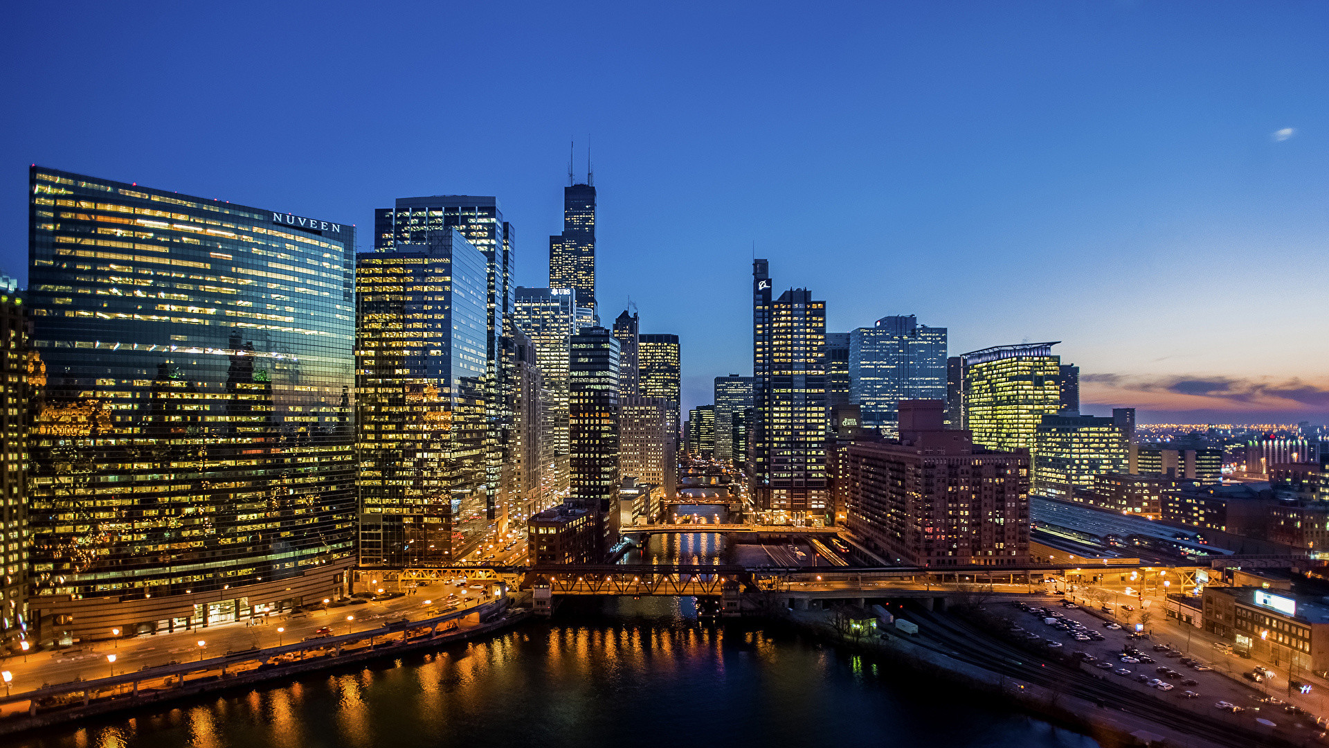 Chicago skyline at dusk, showing the river and illuminated buildings