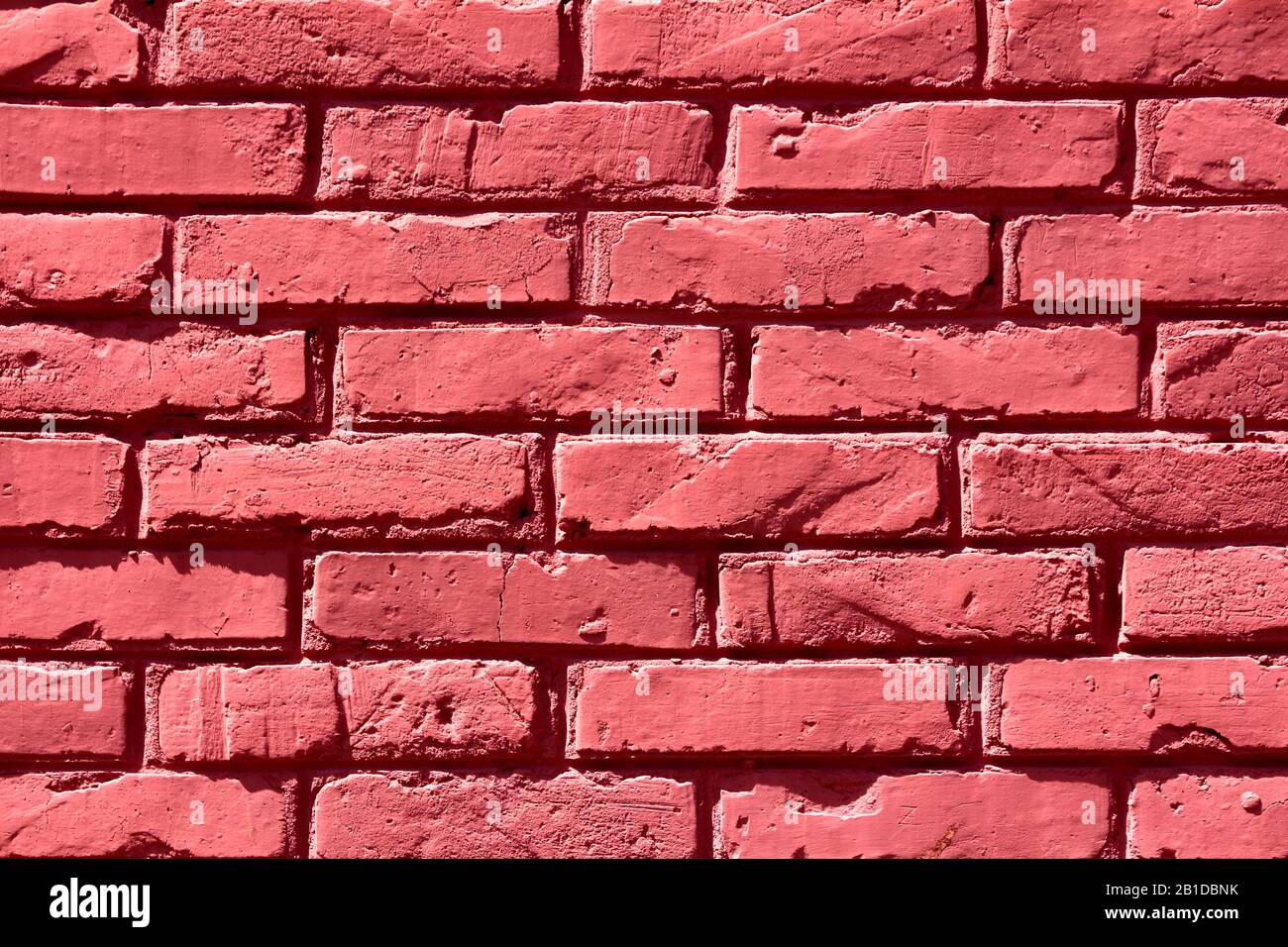 Freshly painted dark red to cherry color cracked damaged bricks