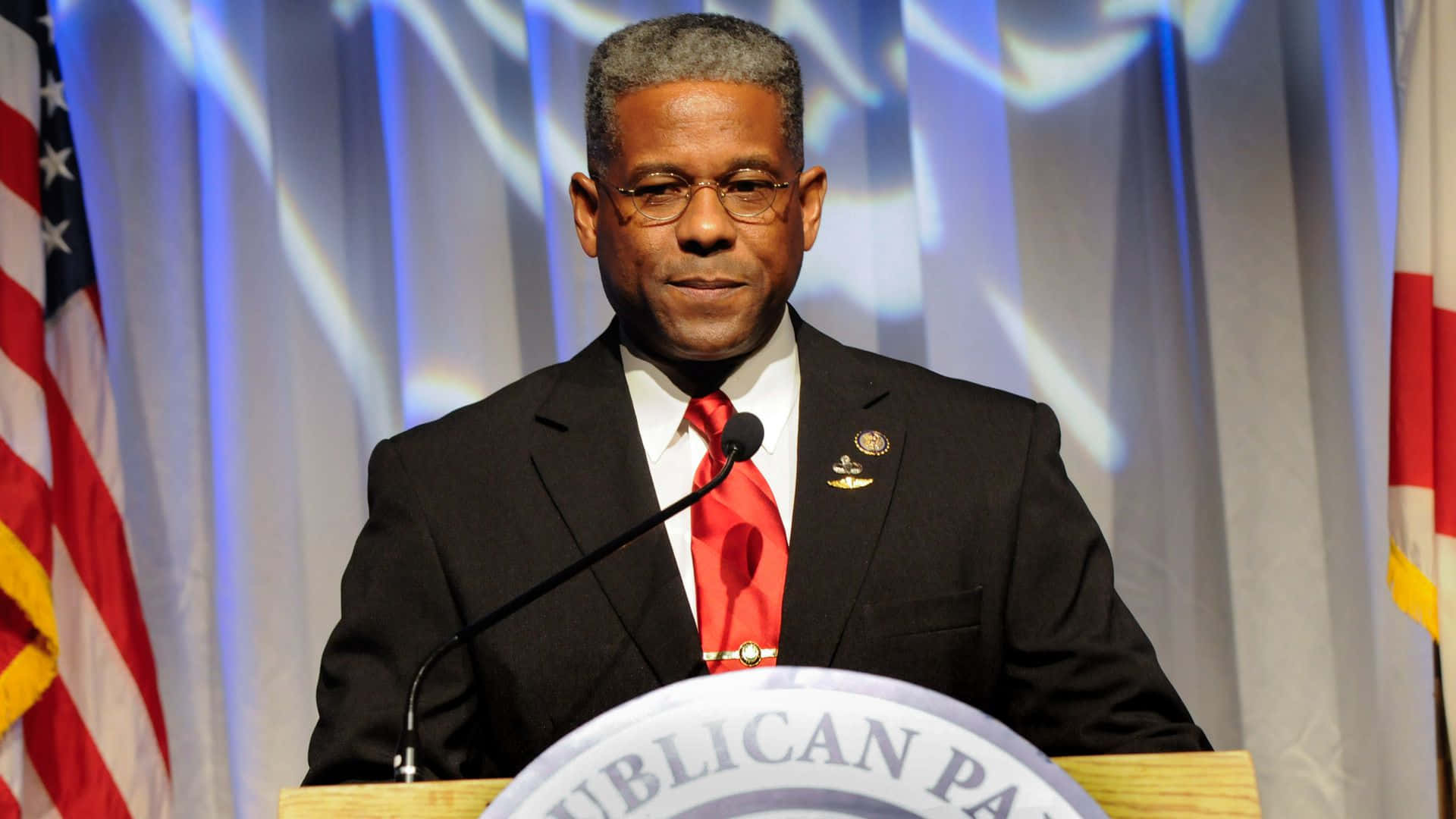 A man in a suit and tie speaking at a Republican Party podium