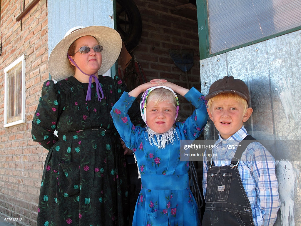 A Mennonite Mother And Two Of Her Children At The Door His