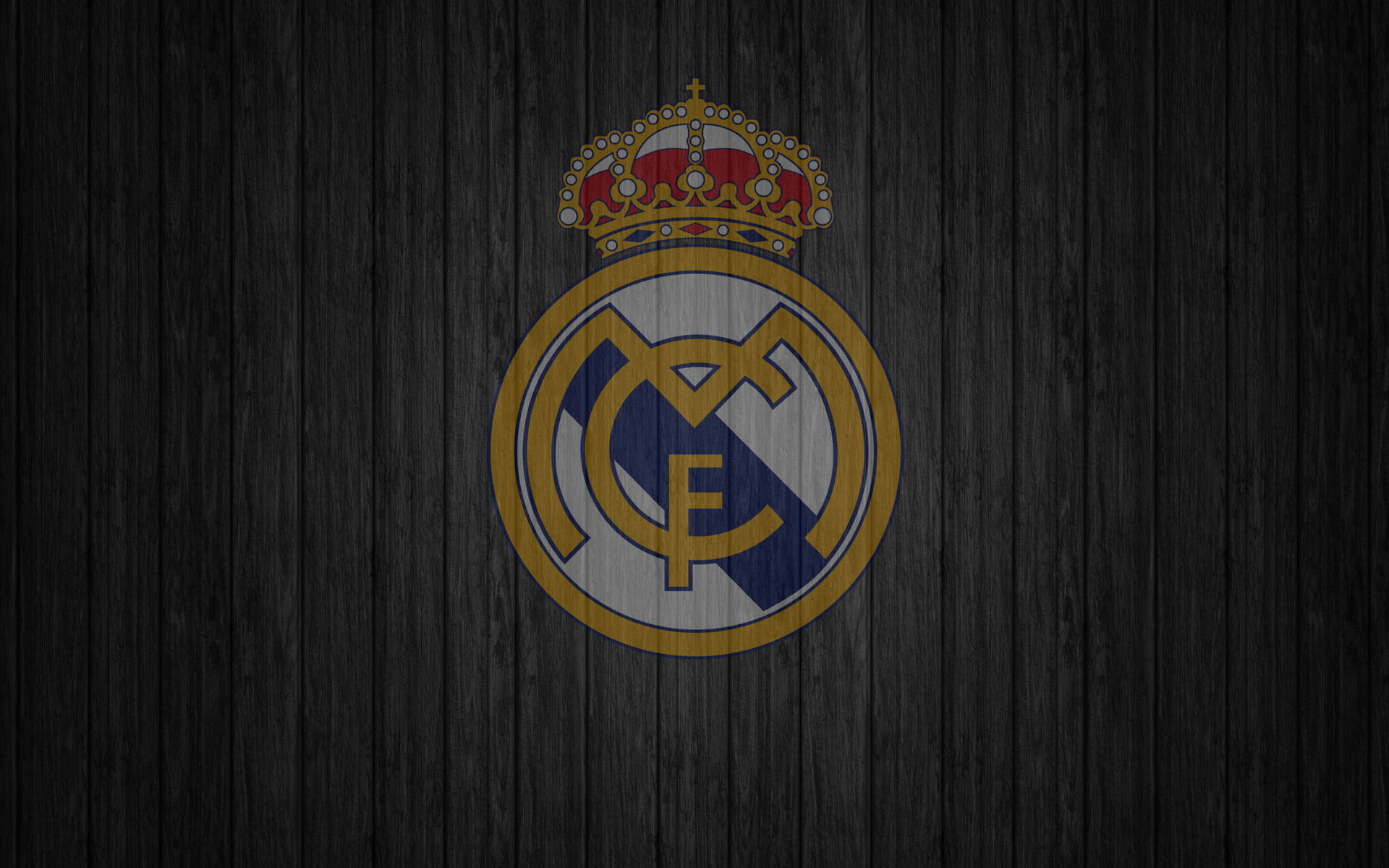 Real Madrid CF logo on a dark wooden background
