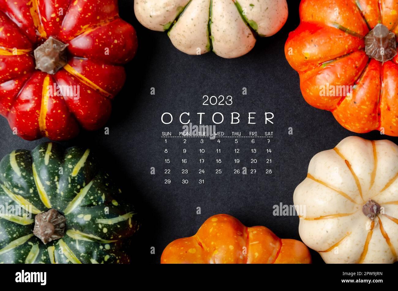 October 2023 Calendar and pumpkins on black cardboard background