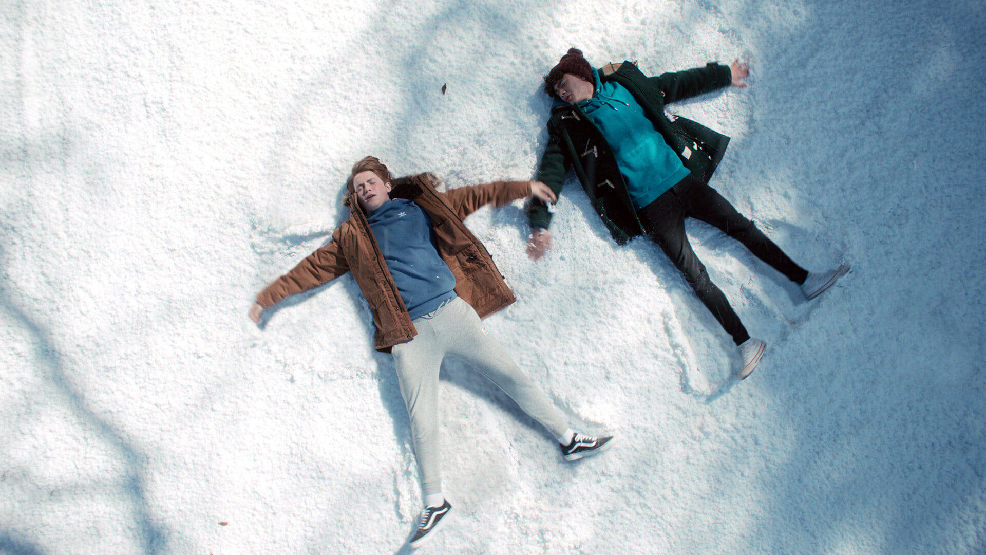 Two people making snow angels in the fresh snow