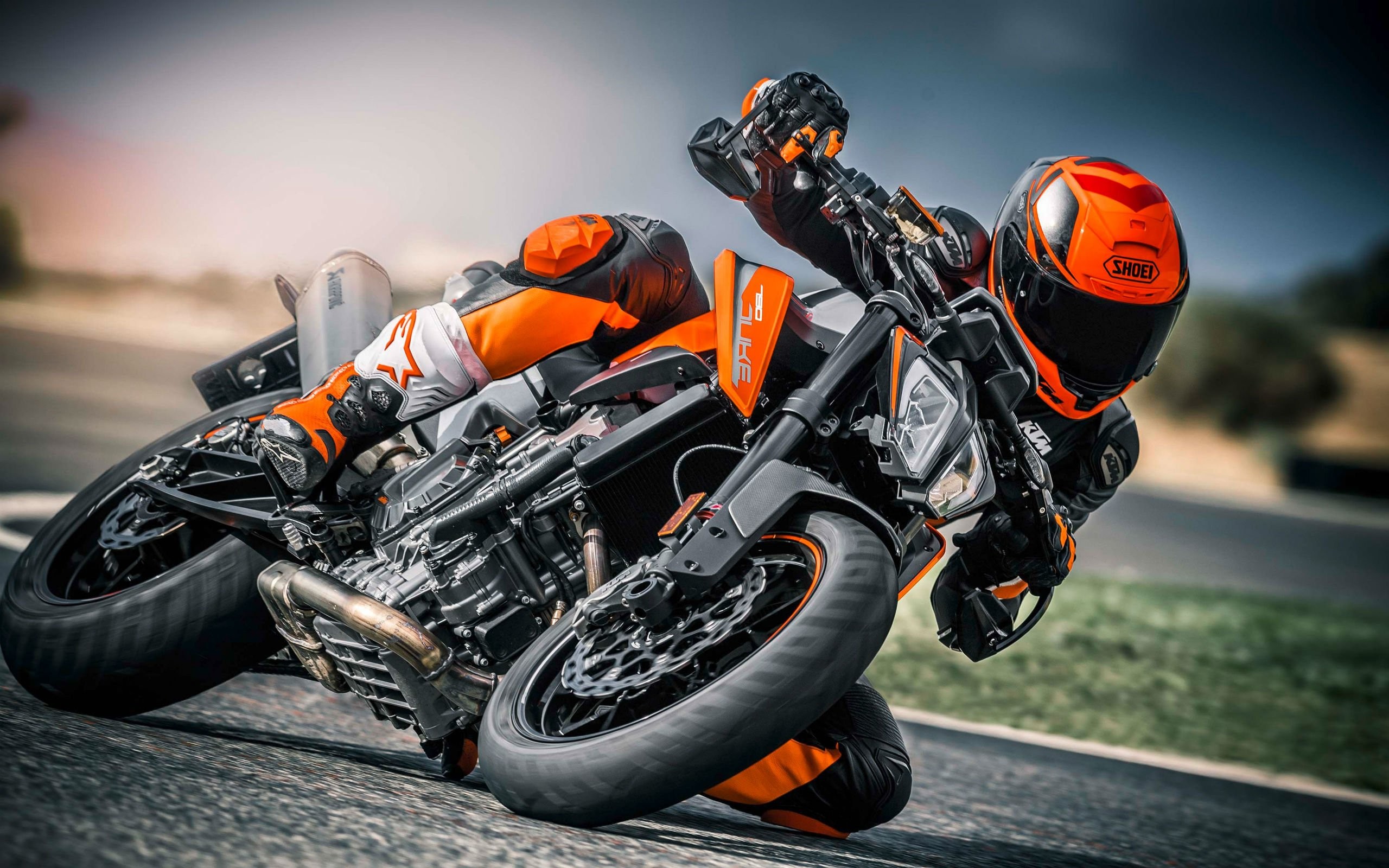 A motorcyclist leans into a turn on a KTM 1290 Super Duke R Evo motorcycle on a racetrack