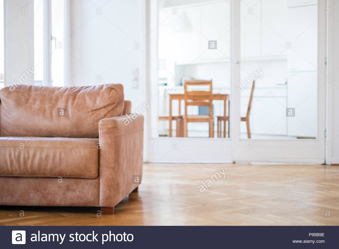 Empty Couch Seat In Living Room With Wooden Floor And Kitchen