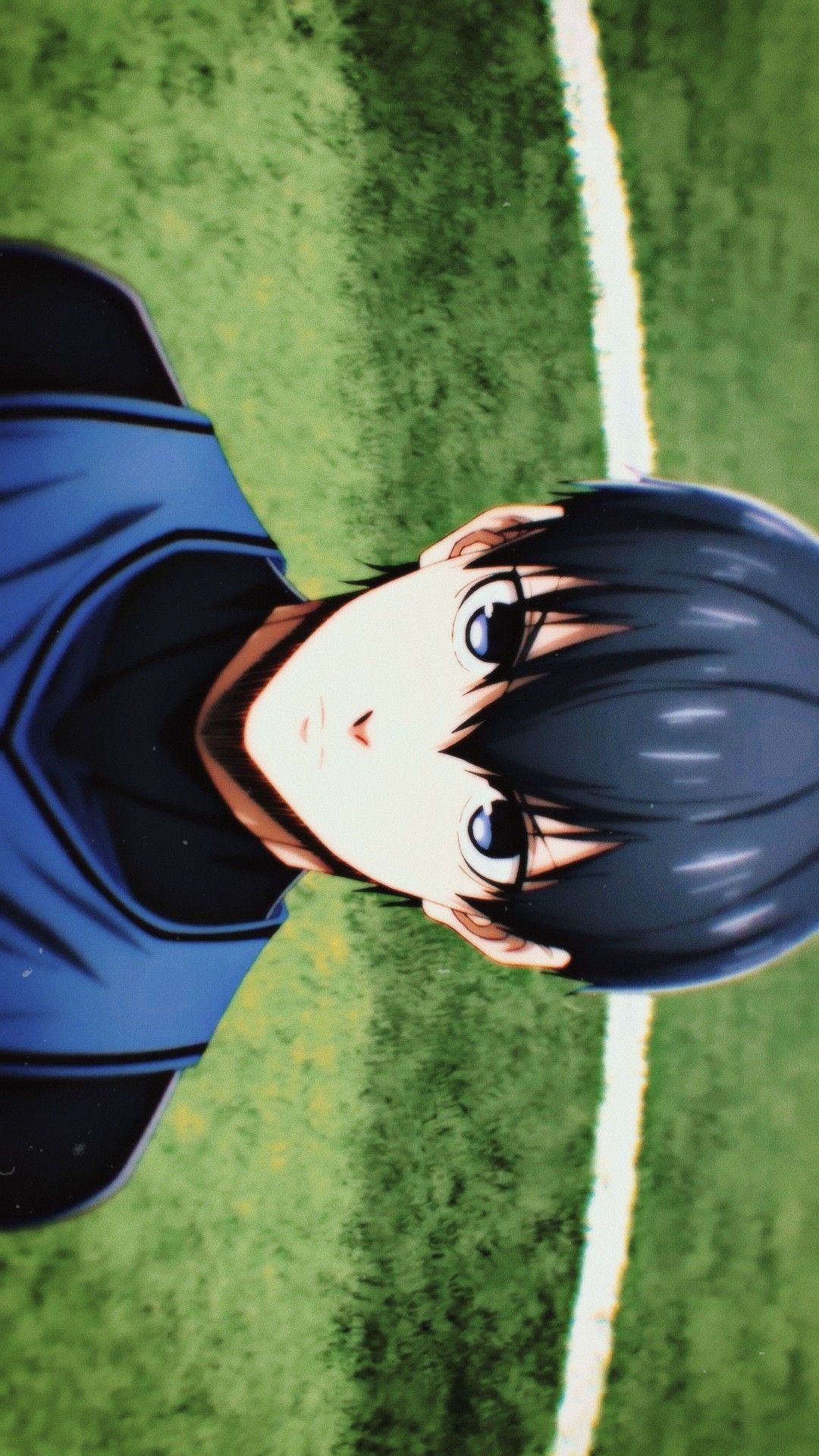 Close-up of Isagi Yoichi from the anime Blue Lock, looking up from a soccer field