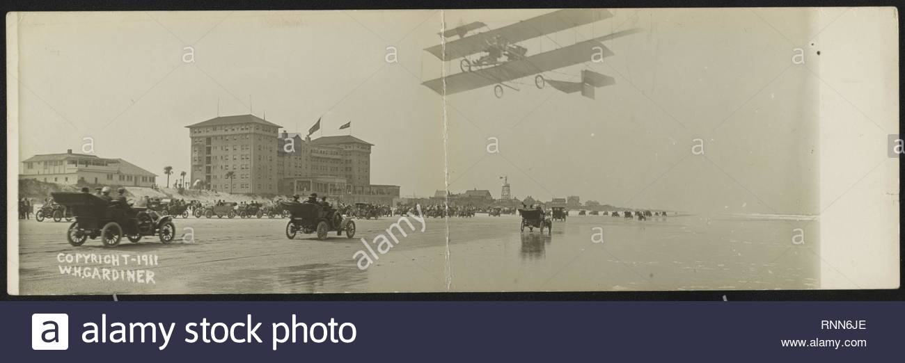 Cars On Beach With Airplane Overhead And Clarendon Hotel In