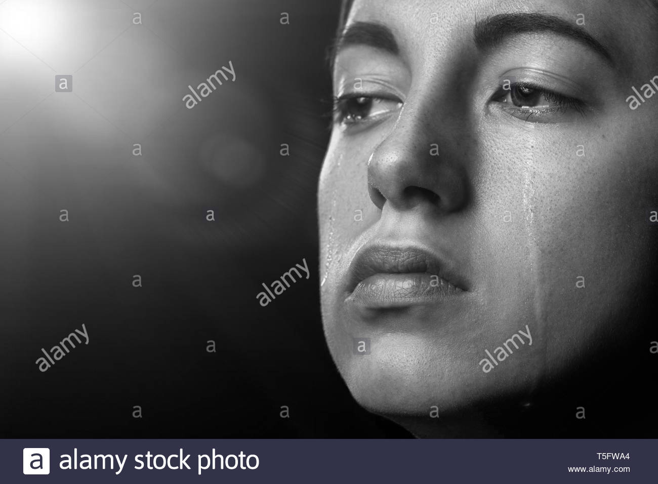 Sad Woman Crying On Black Background With Light Rays Closeup