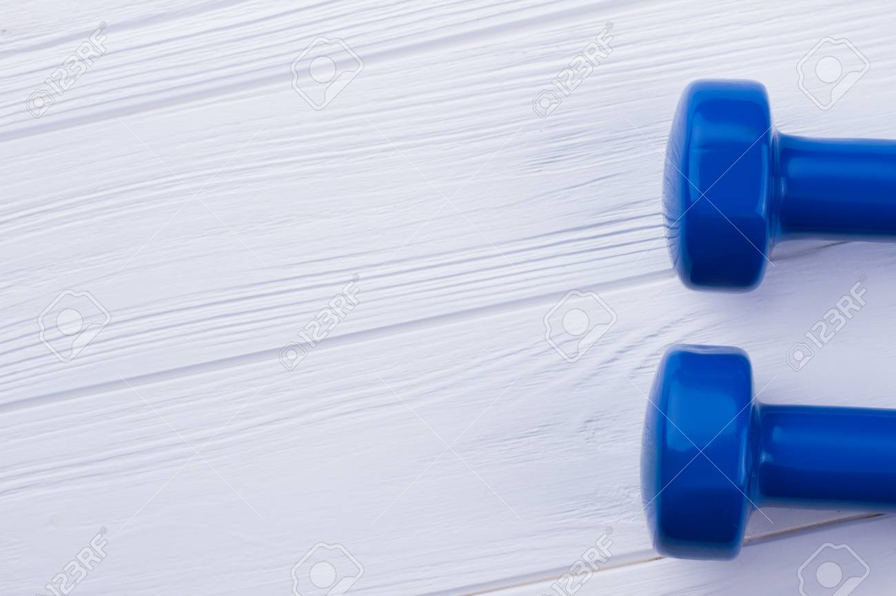 Blue Dumbbells On White Wooden Background Fitness Equipment