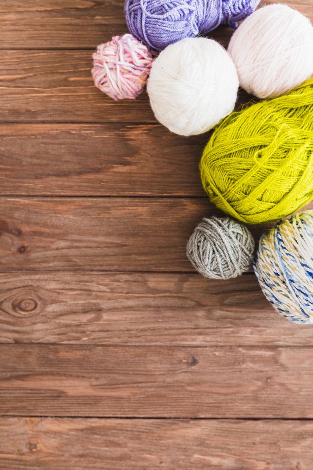 Multi Colored Ball Of Yarns On Wooden Background Photo