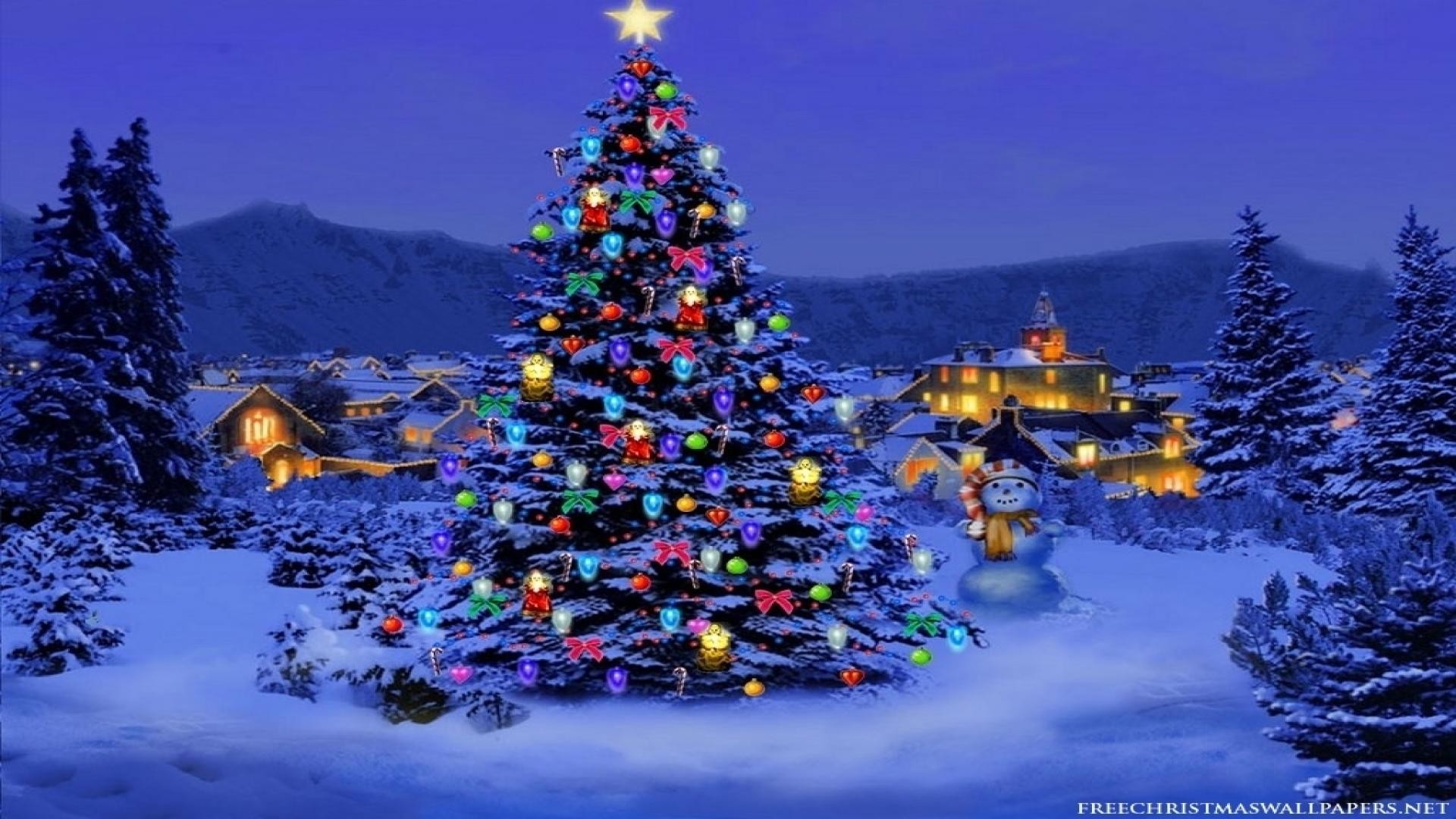 A decorated Christmas tree in a snowy village at night, perfect for a Christmas computer wallpaper