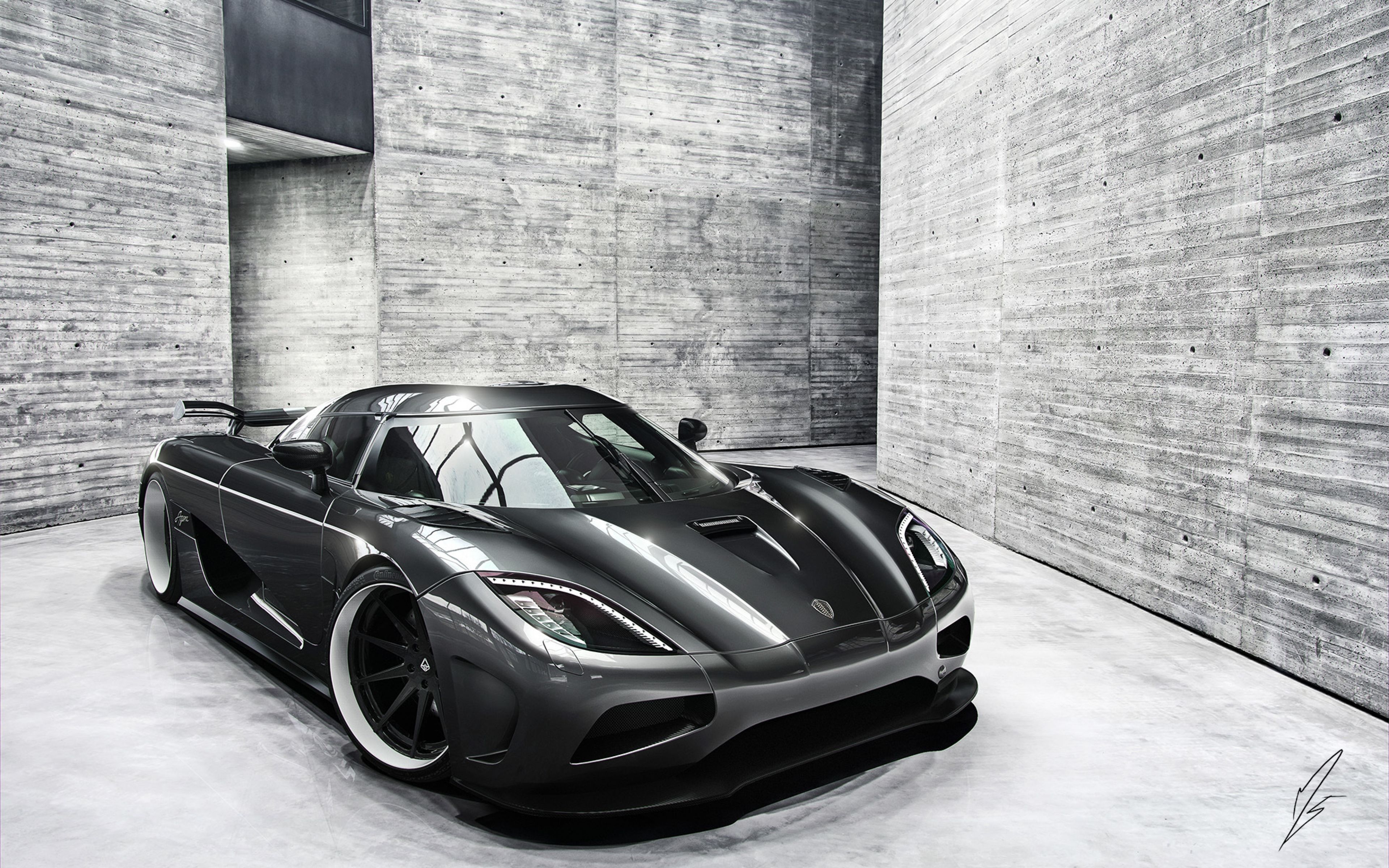 Sleek black Koenigsegg Agera parked in a modern, minimalist concrete garage