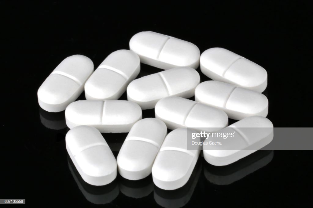 White Narcotic Pain Reliever Pills On A Black Background High Res