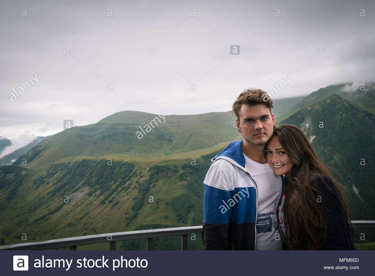 Young Couple Stands At Observation Deck On Background Of Beautiful