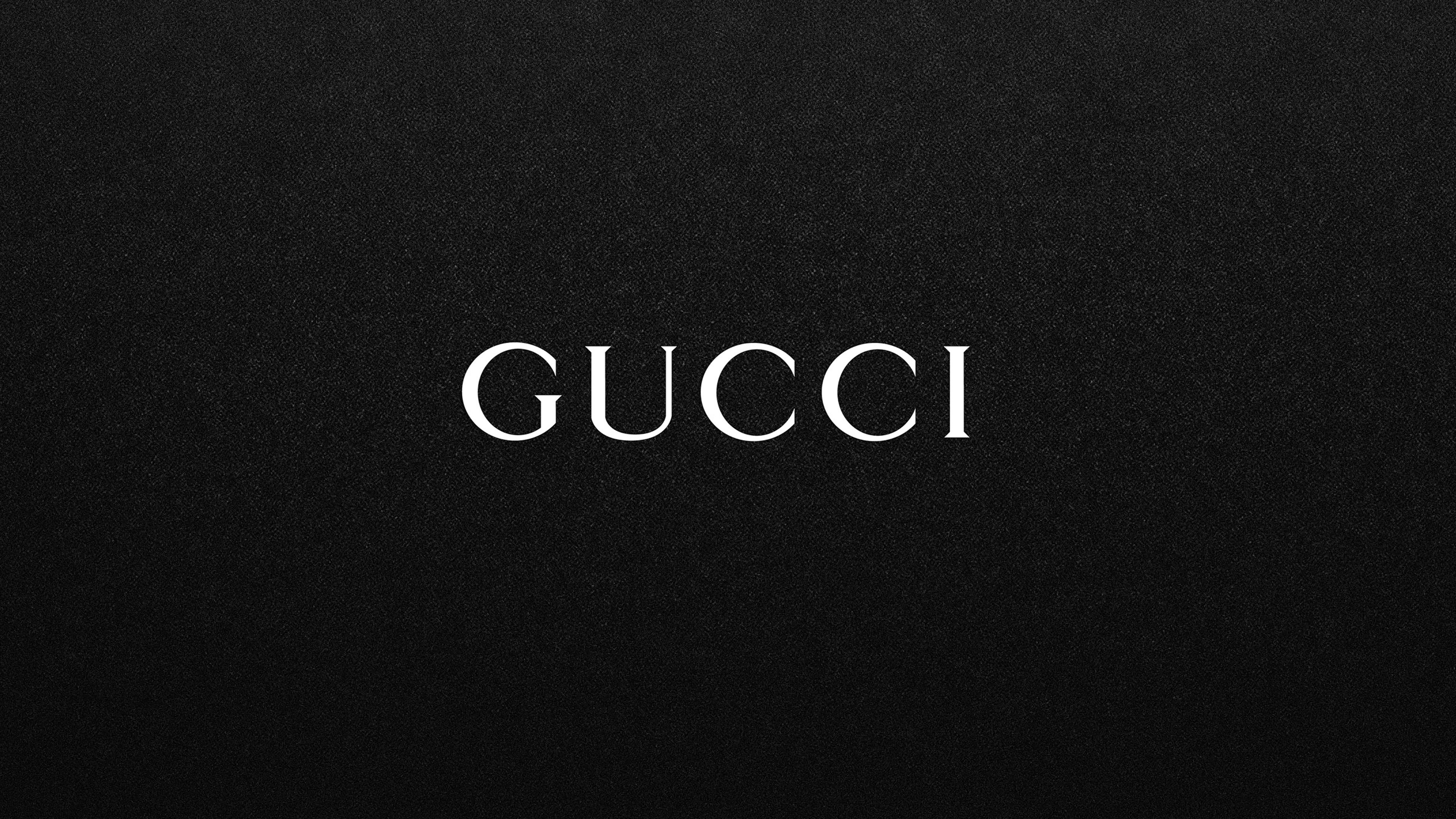 Gucci logo on a black textured background