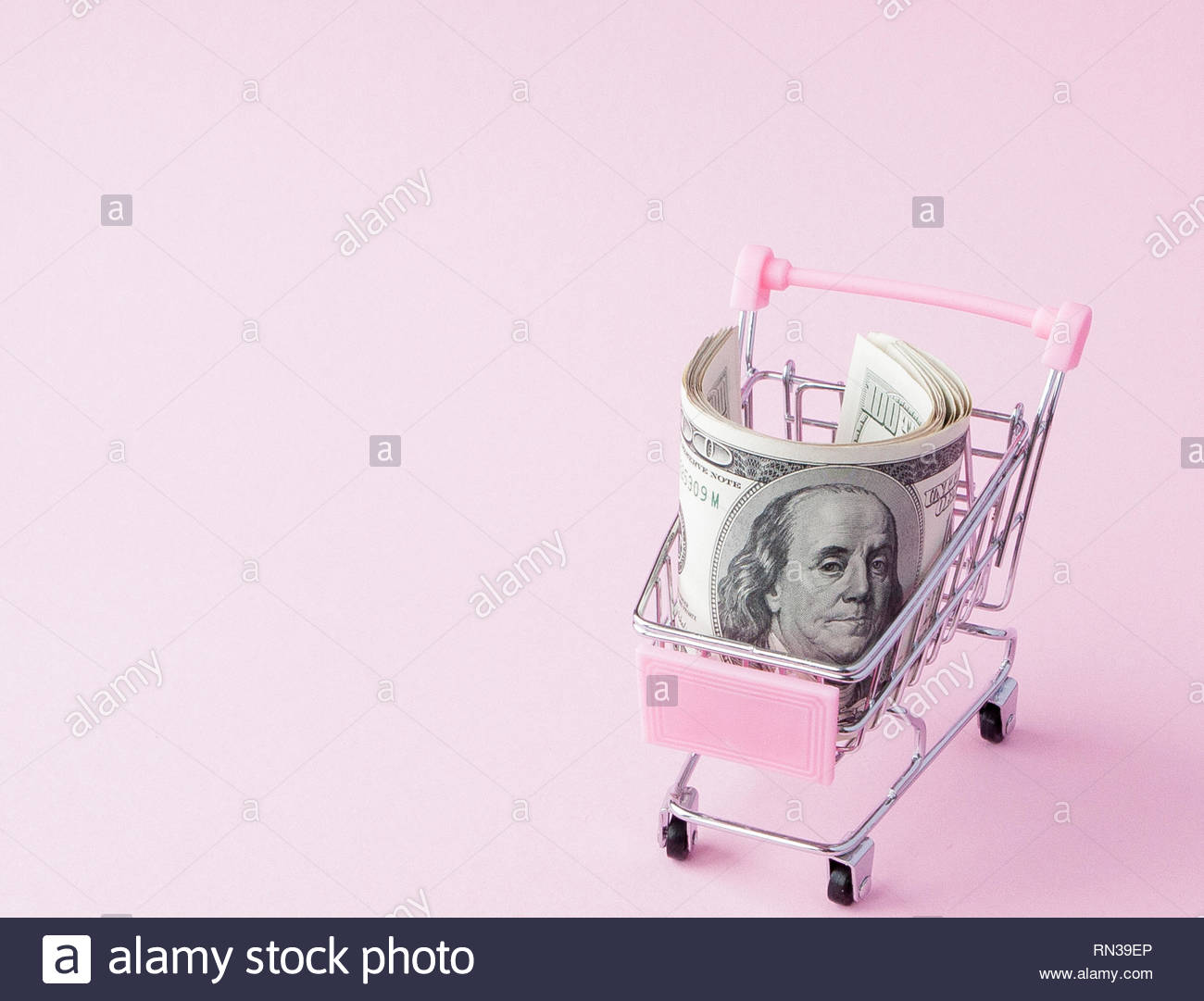 Supermarket Cart Full Of Us Dollar Banknotes On A Pink Background