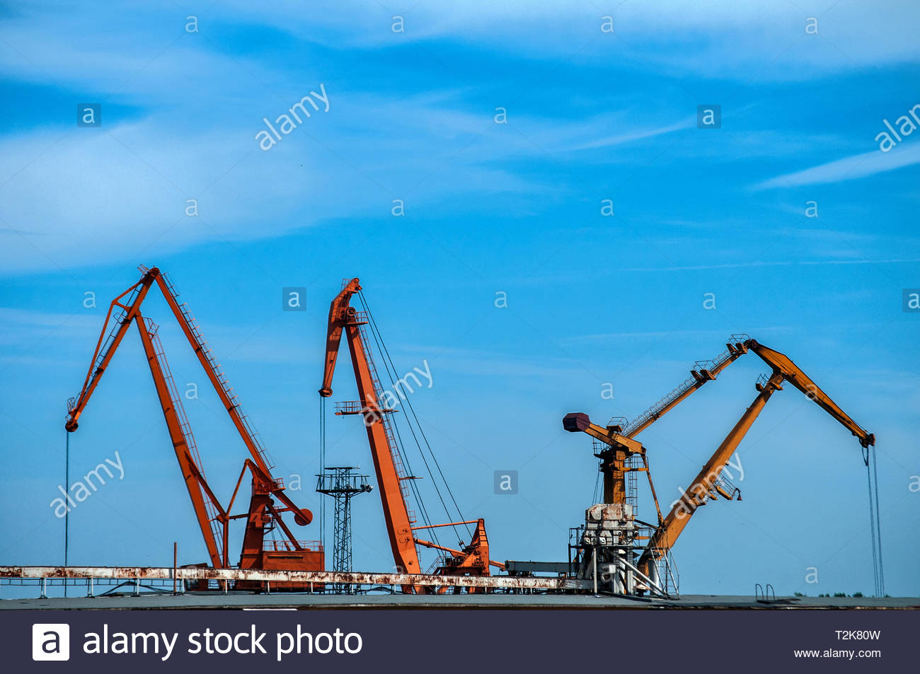 Industrial Scene With River Port Crane Facilities On Blue Sky