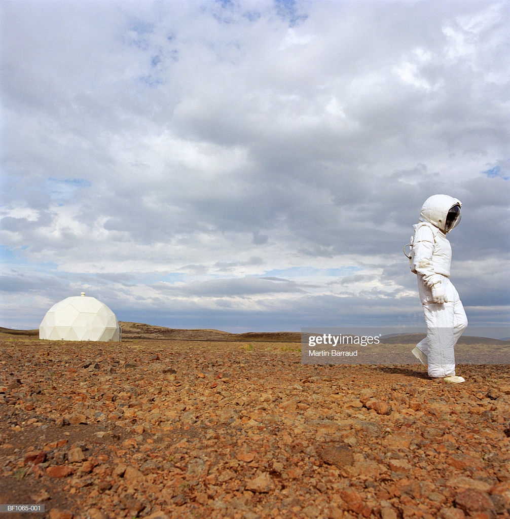 Man In Space Suit Walking Across Rocky Ground Radome Background