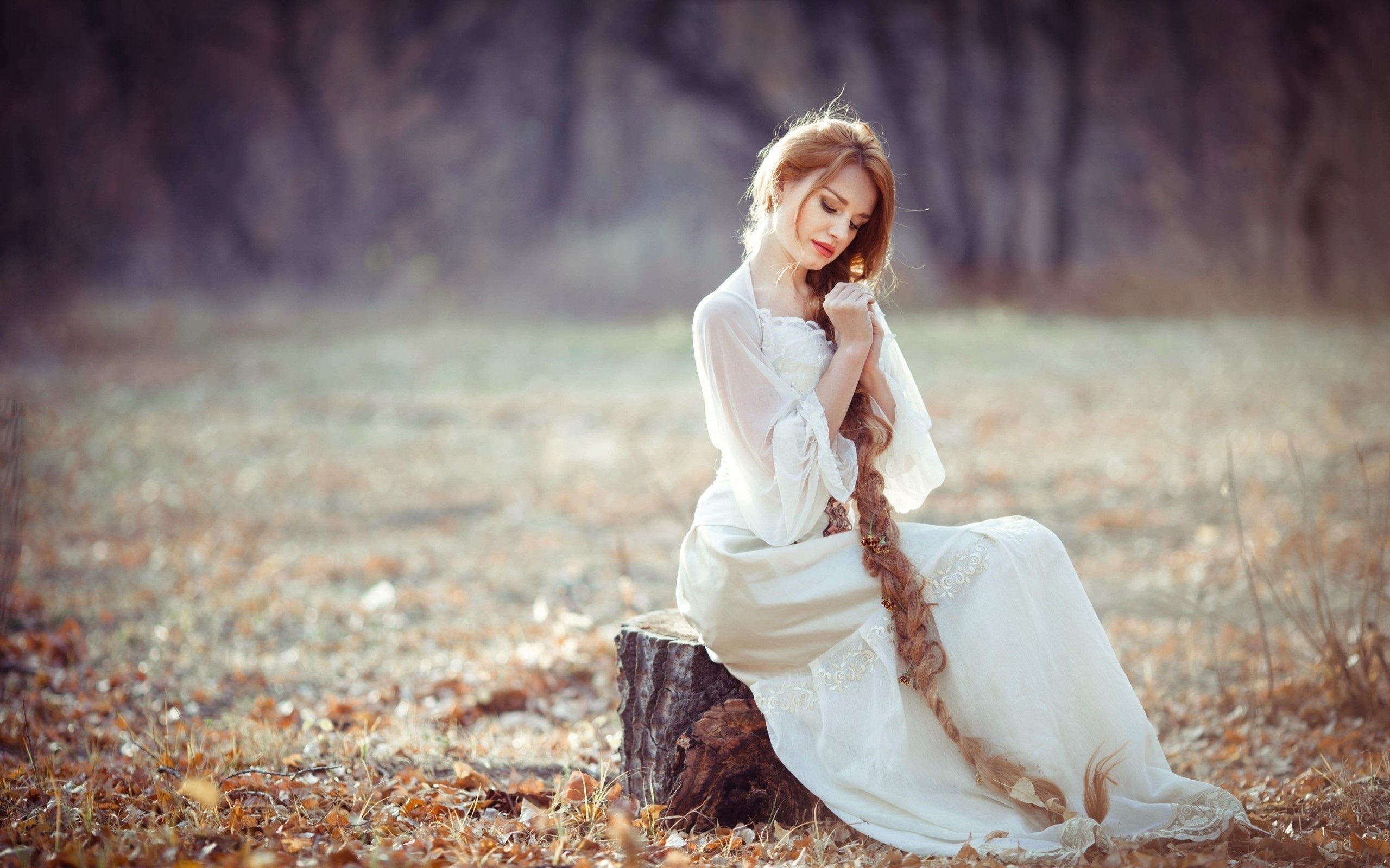 White dress girl sitting on stump long blonde hair