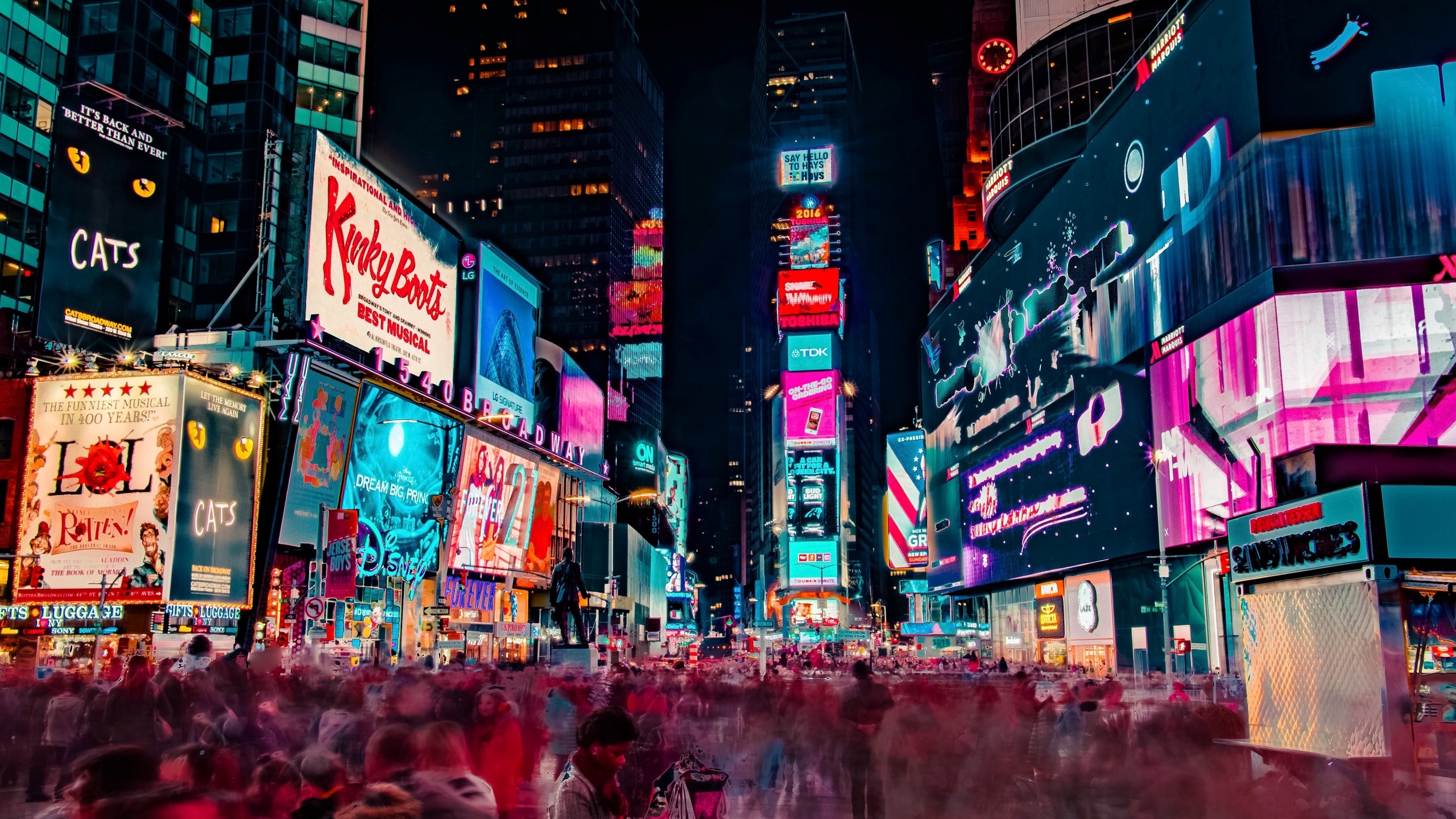 A vibrant night scene of Times Square in New York City, showcasing the dazzling Broadway show billboards and the bustling crowds