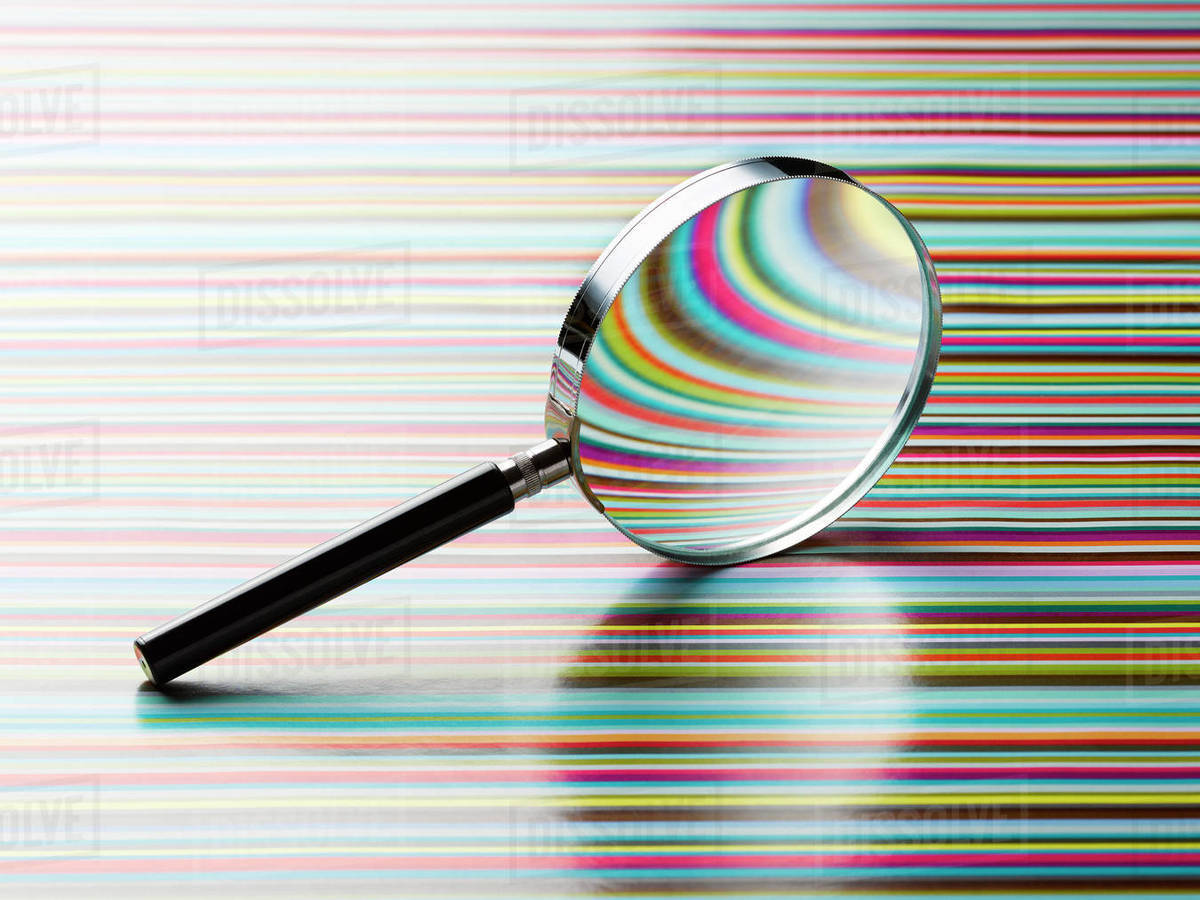 Magnifying Glass Leaning On Striped Background Stock Photo
