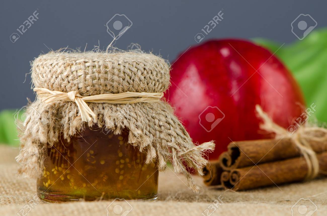 Peach Jam With Fruit And Cinnamon Over Raffia Background Stock