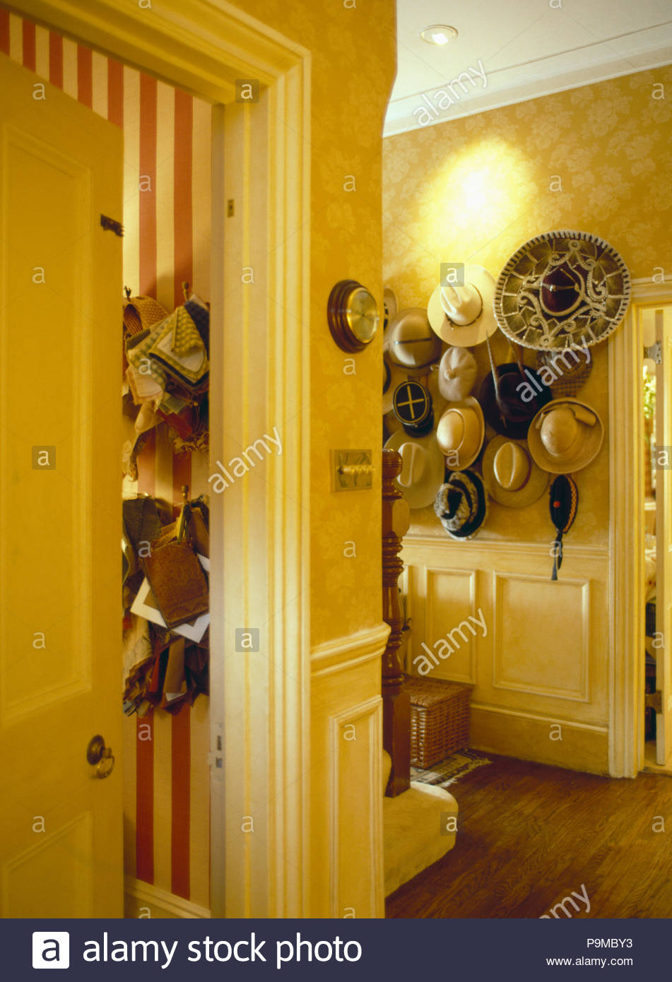 Patterned Wallpaper In Yellow Hall With Collection Of Hats On Wall