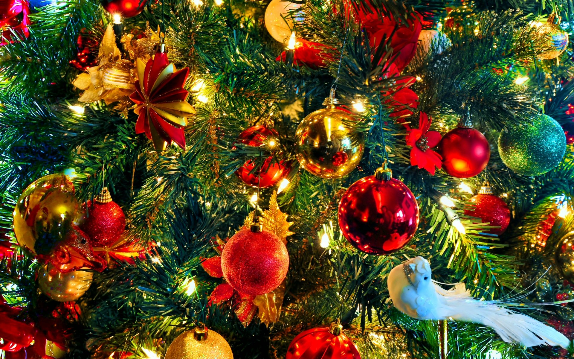 Close-up of a Christmas tree adorned with colorful ornaments, lights, and a decorative white dove, evoking a festive holiday spirit