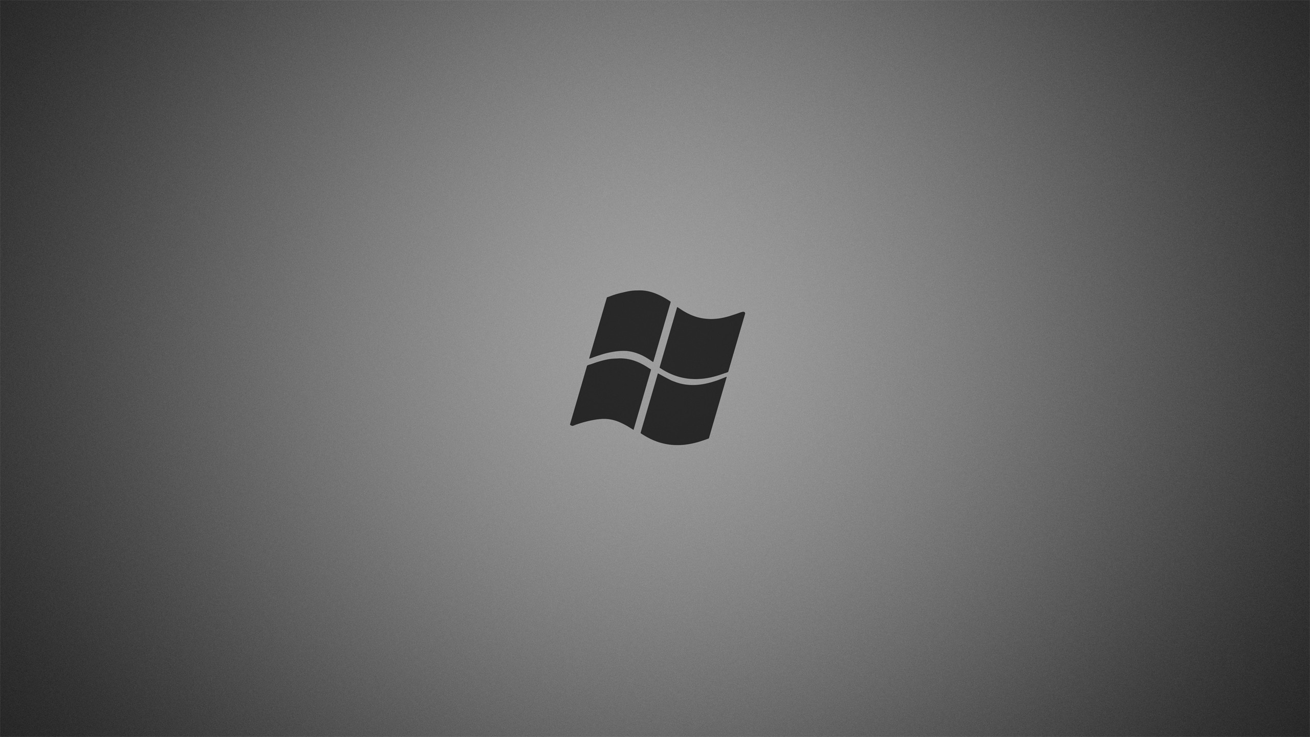 Minimalist gray wallpaper featuring a subtle Windows logo