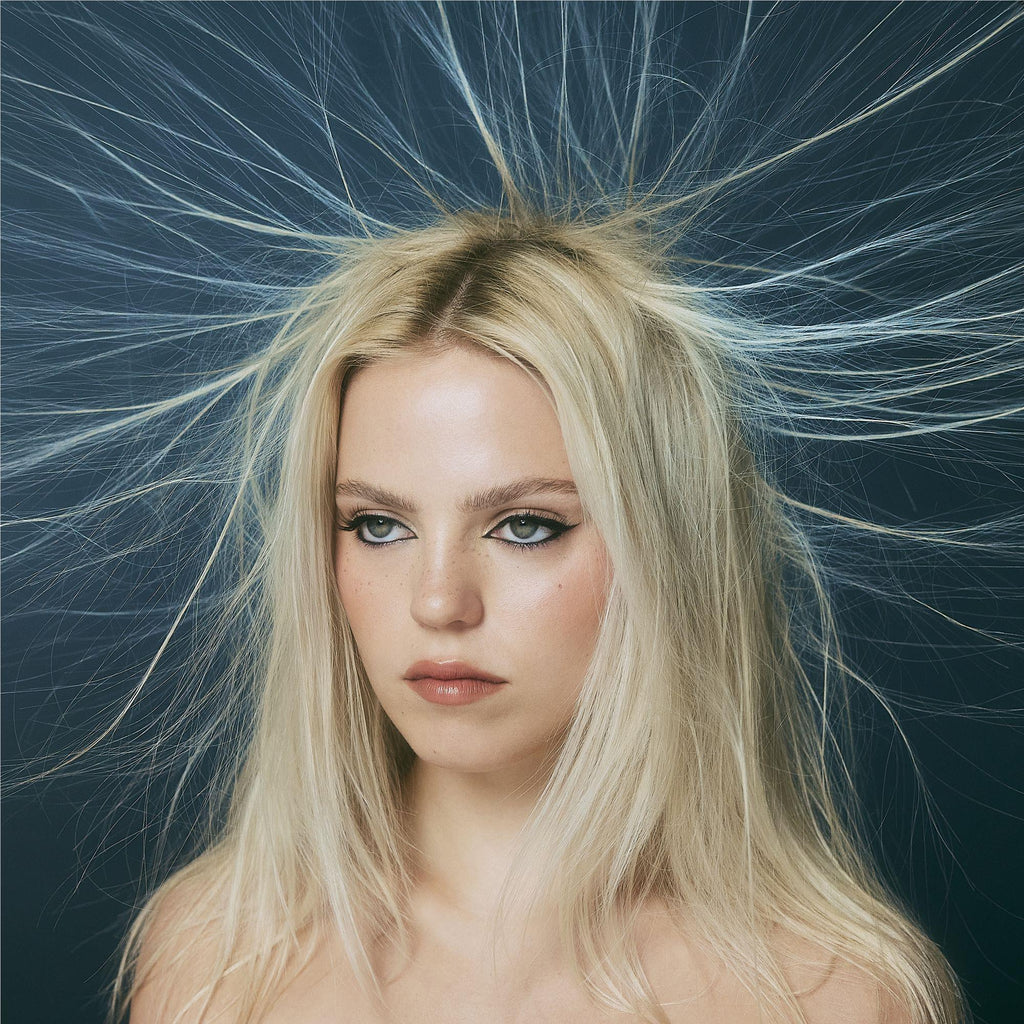 A blonde woman with static hair against a dark background