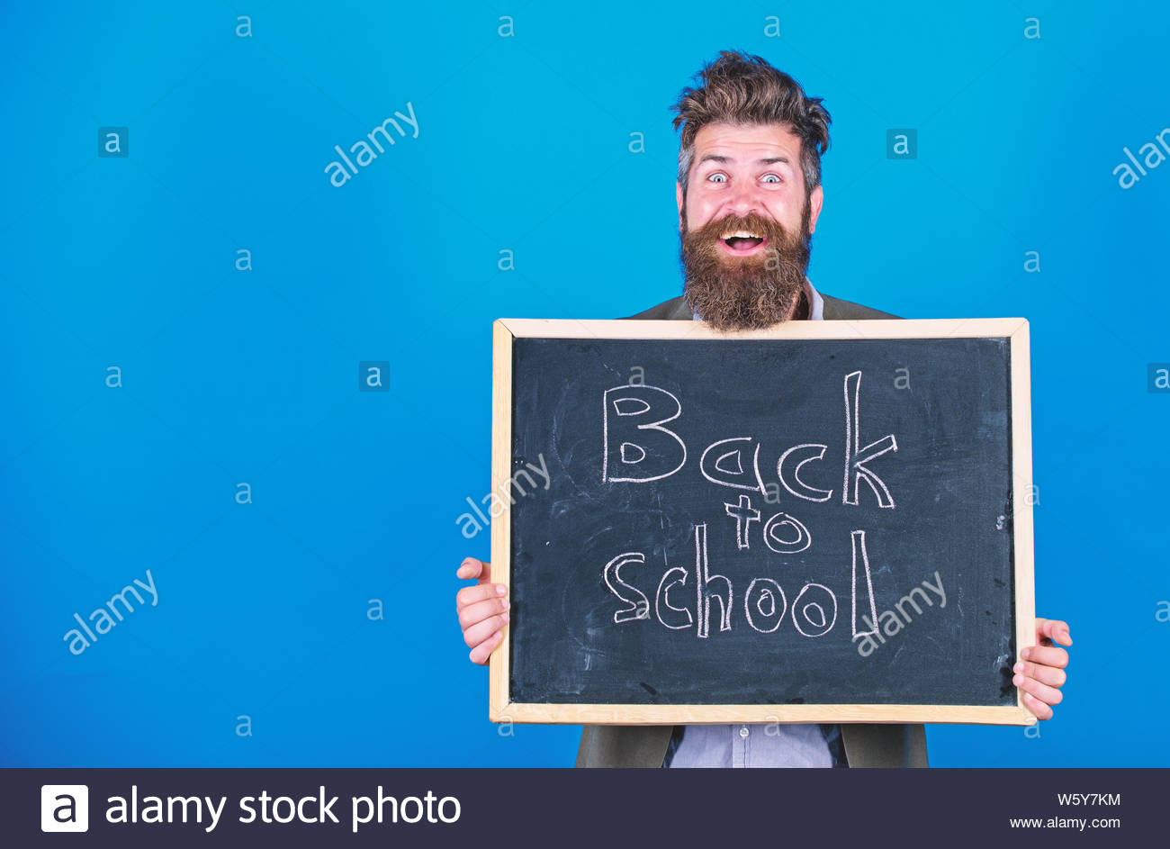 Teacher Bearded Man Stands And Holds Blackboard With Inscription
