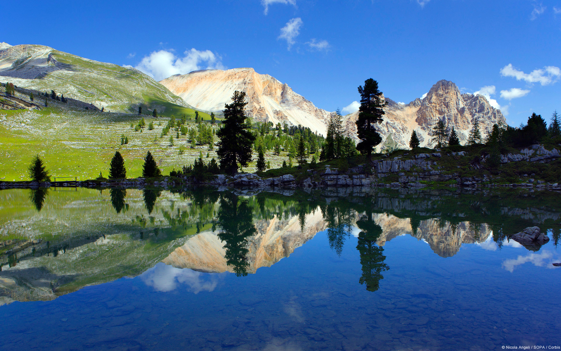 Serene mountain lake reflecting the sky and peaks