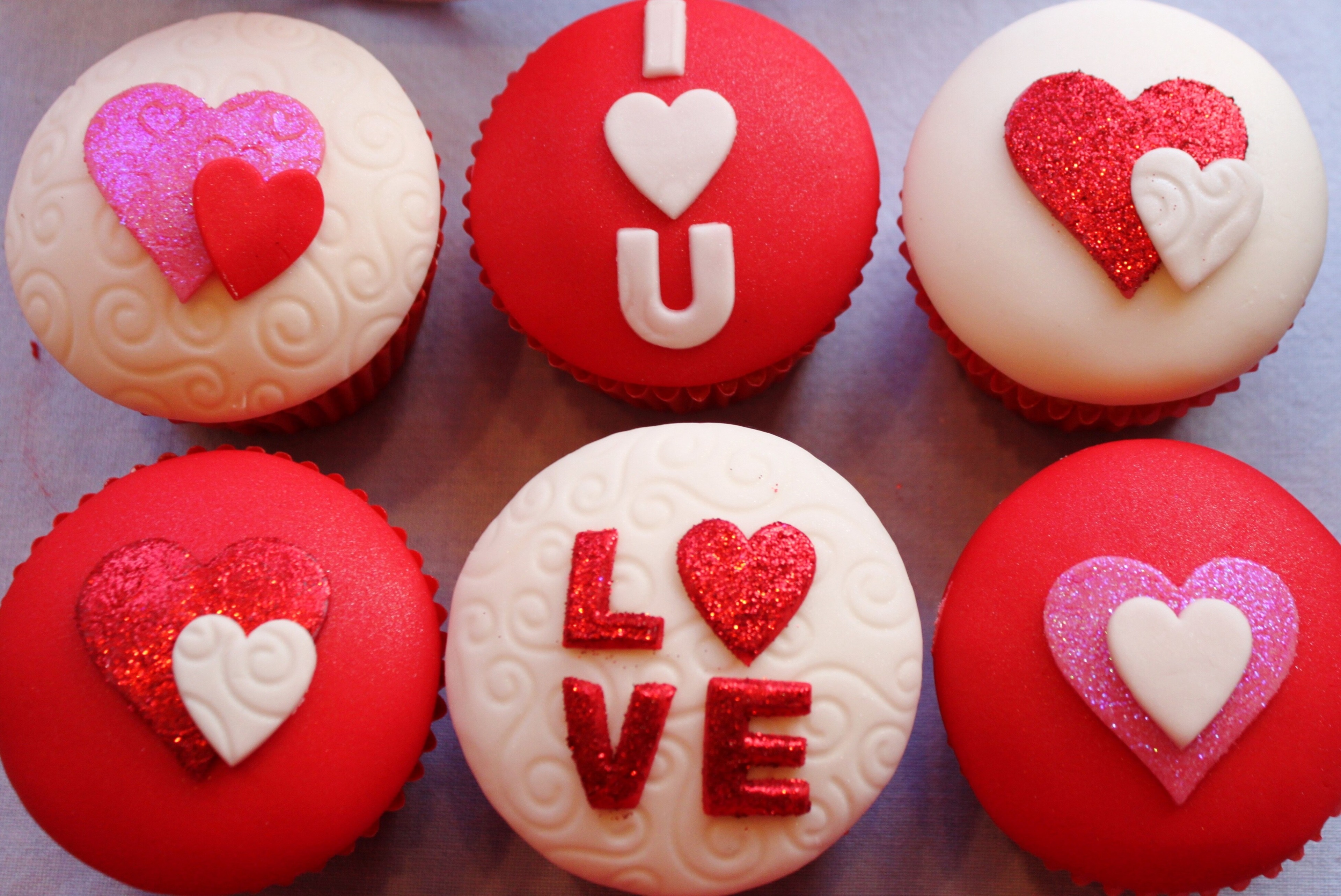 Close-up of Valentine's Day cupcakes decorated with hearts and the words 'I love you'