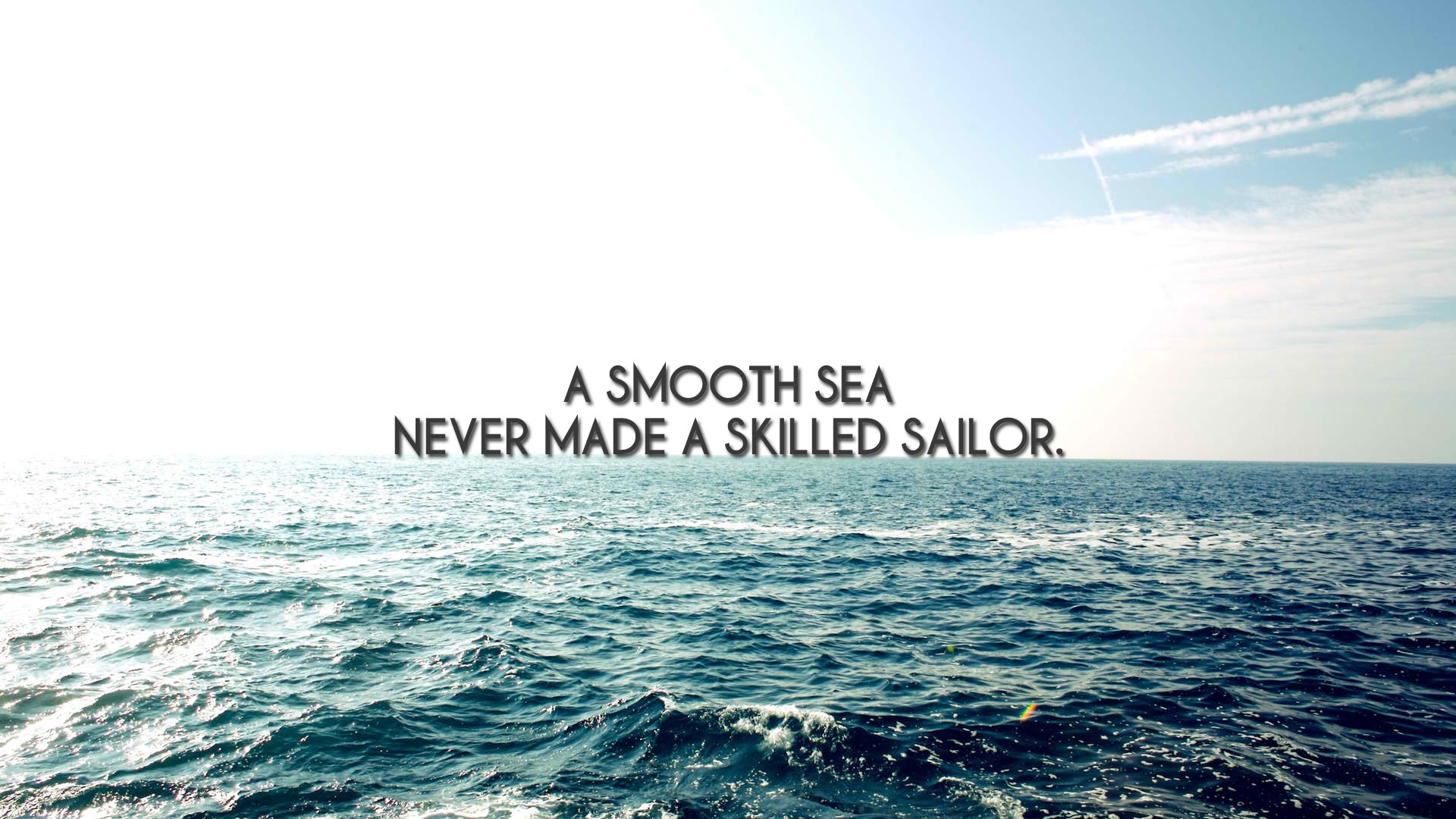 Inspirational image of the ocean with the quote 'A smooth sea never made a skilled sailor'
