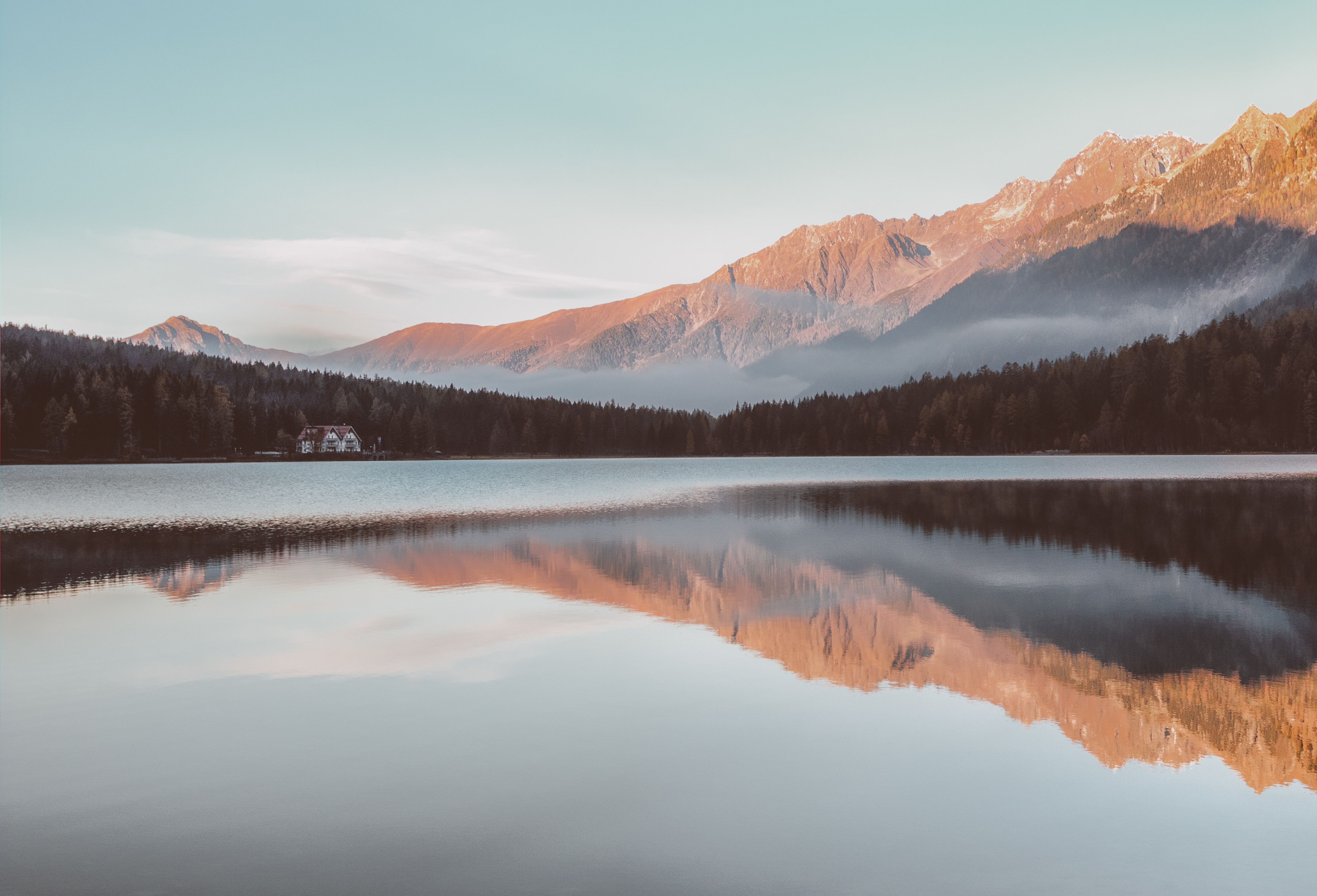 Serene lake reflecting majestic mountains at sunset in 4K resolution