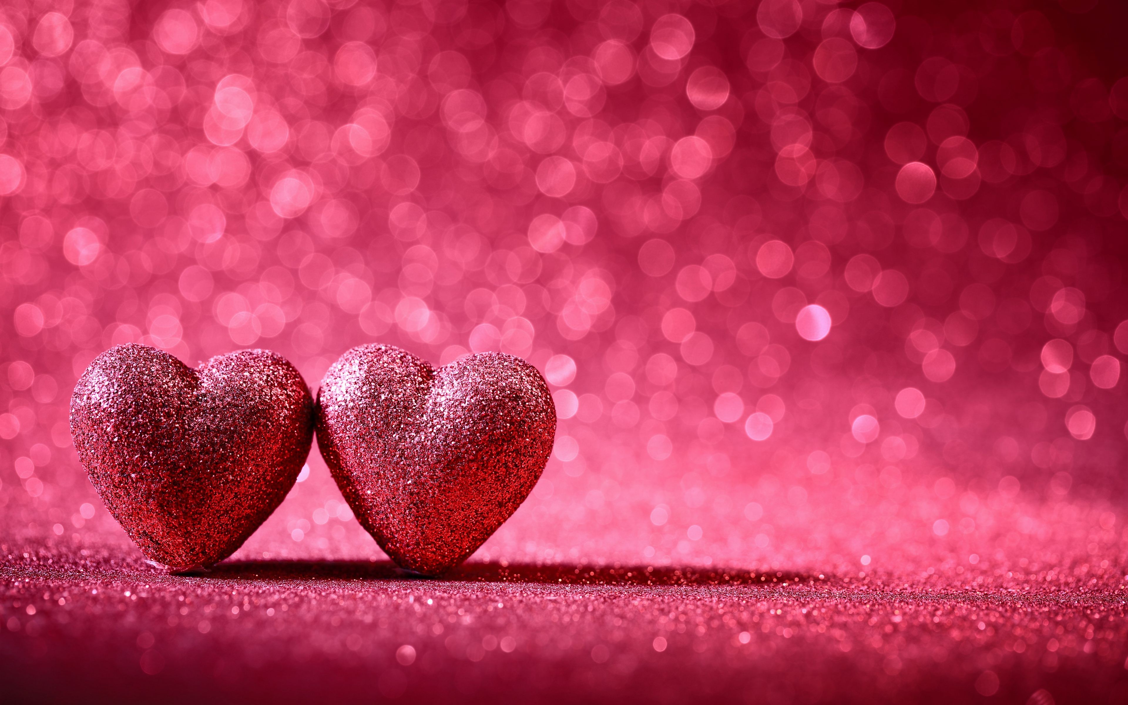 Two glittering red hearts on a sparkly pink background, perfect for Valentine's Day or romantic occasions