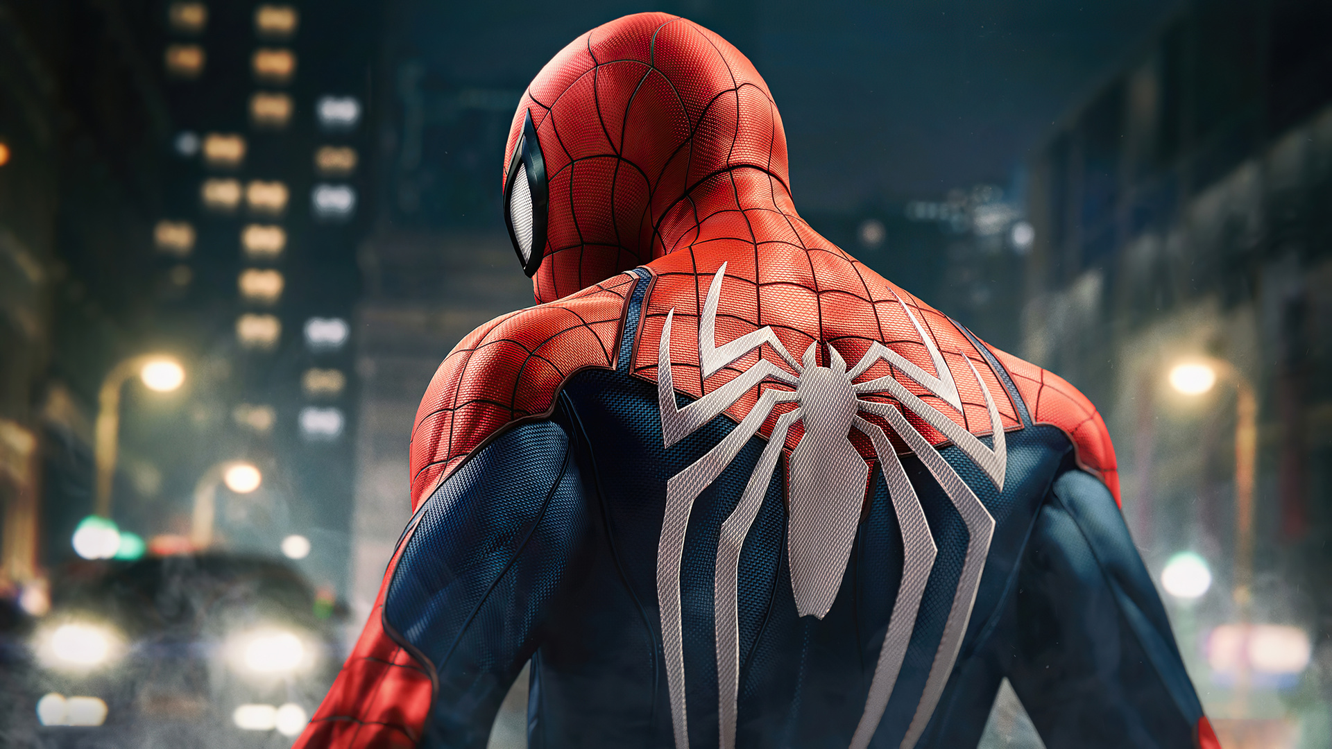 Spider-Man standing with his back to the camera in a city at night, showcasing the white spider symbol on his suit, from the PC game Marvel's Spider-Man