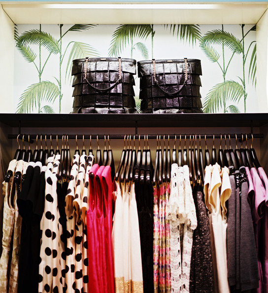 Palm Frond Wallpaper Above A Rack Of Kate Spade