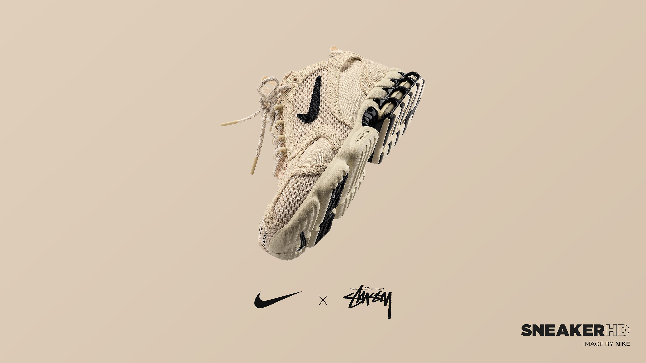 Close-up of a Stüssy x Nike Air Zoom Spiridon Cage 2 sneaker against a neutral background, highlighting the shoe's design and collaboration branding