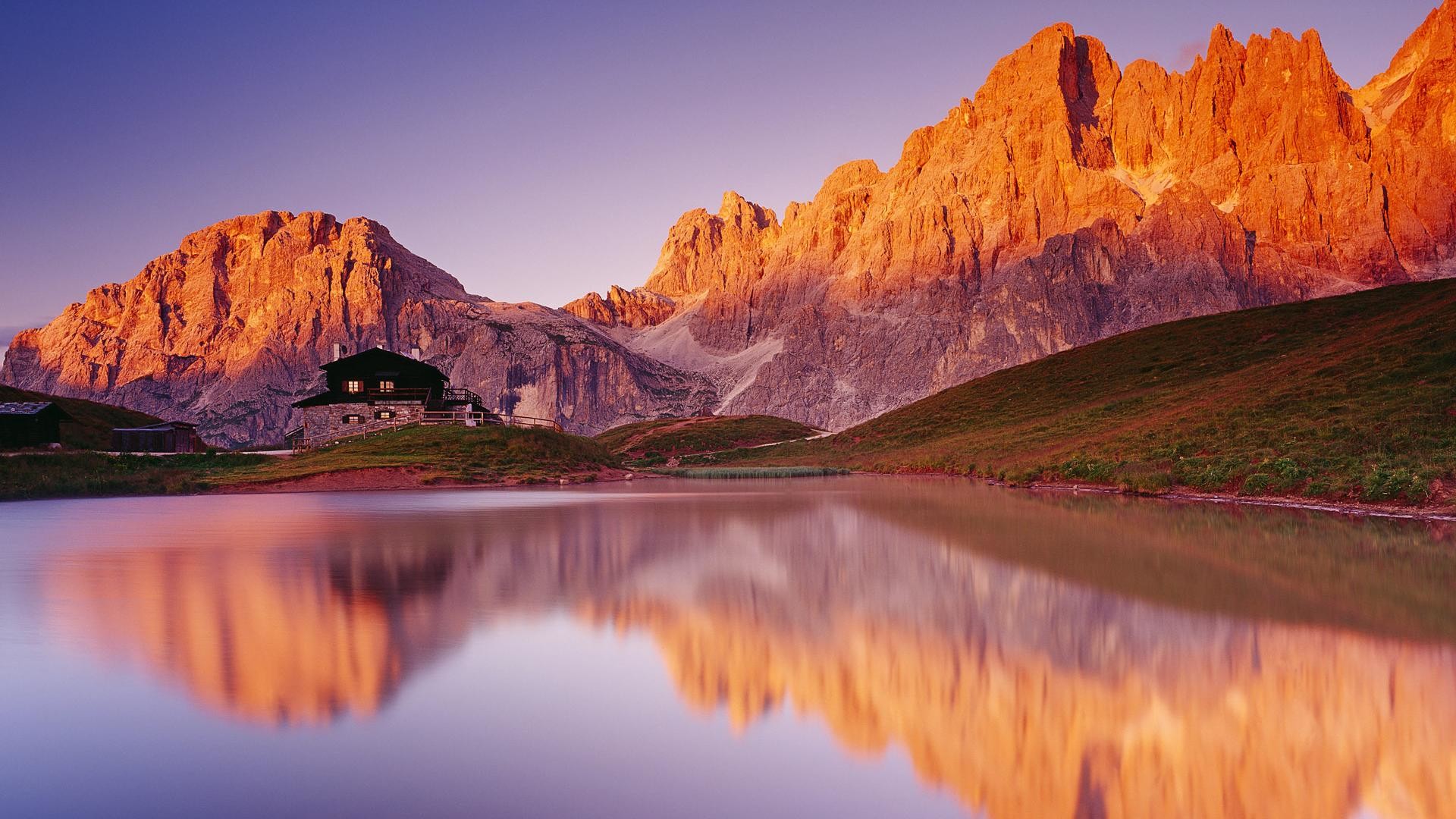 Stunning mountain range reflected in a calm alpine lake at sunset, creating a picturesque and serene landscape