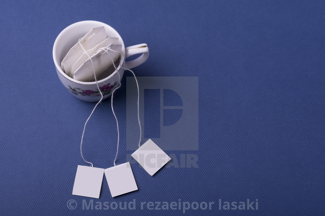 Porcelain White Cup With Three Tea Bags On Dark Blue Background